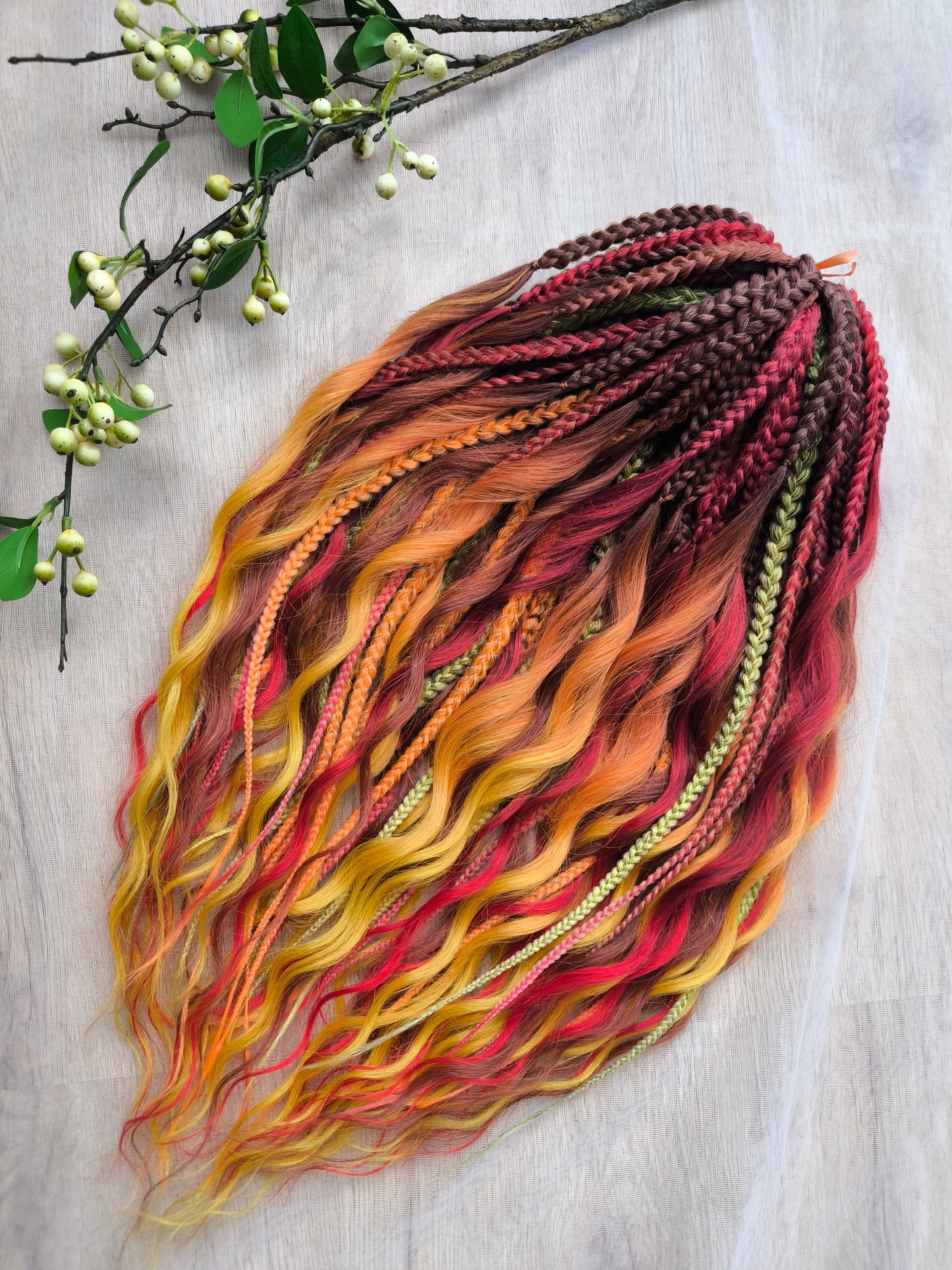 Mountain Sunrise: soft, lightweight, and reusable 55 double-ended synthetic braids with loose wavy brushable ends in red, bronze, yellow, and orange colors.