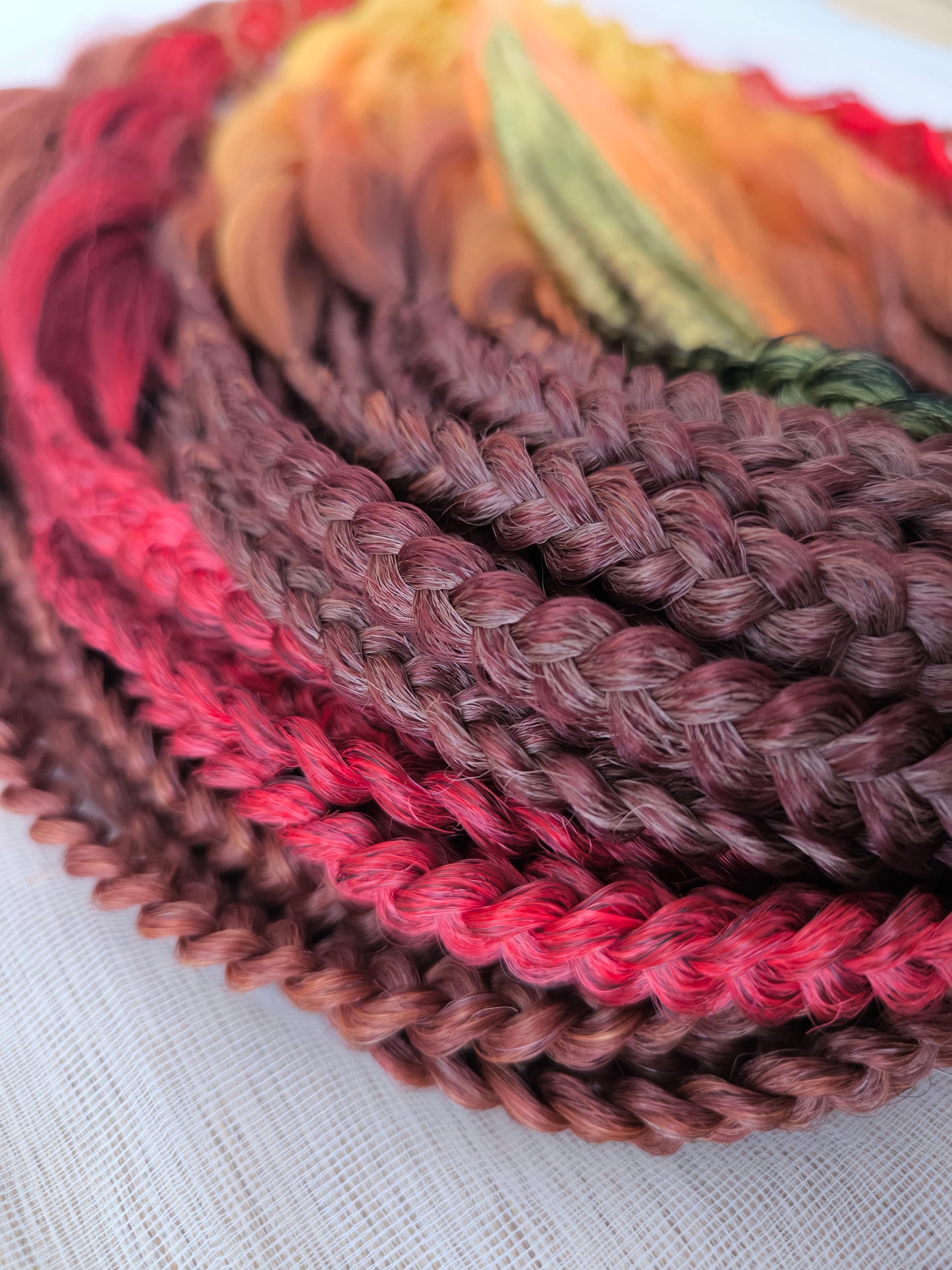 Mountain Sunrise: soft, lightweight, and reusable 55 double-ended synthetic braids with loose wavy brushable ends in red, bronze, yellow, and orange colors.