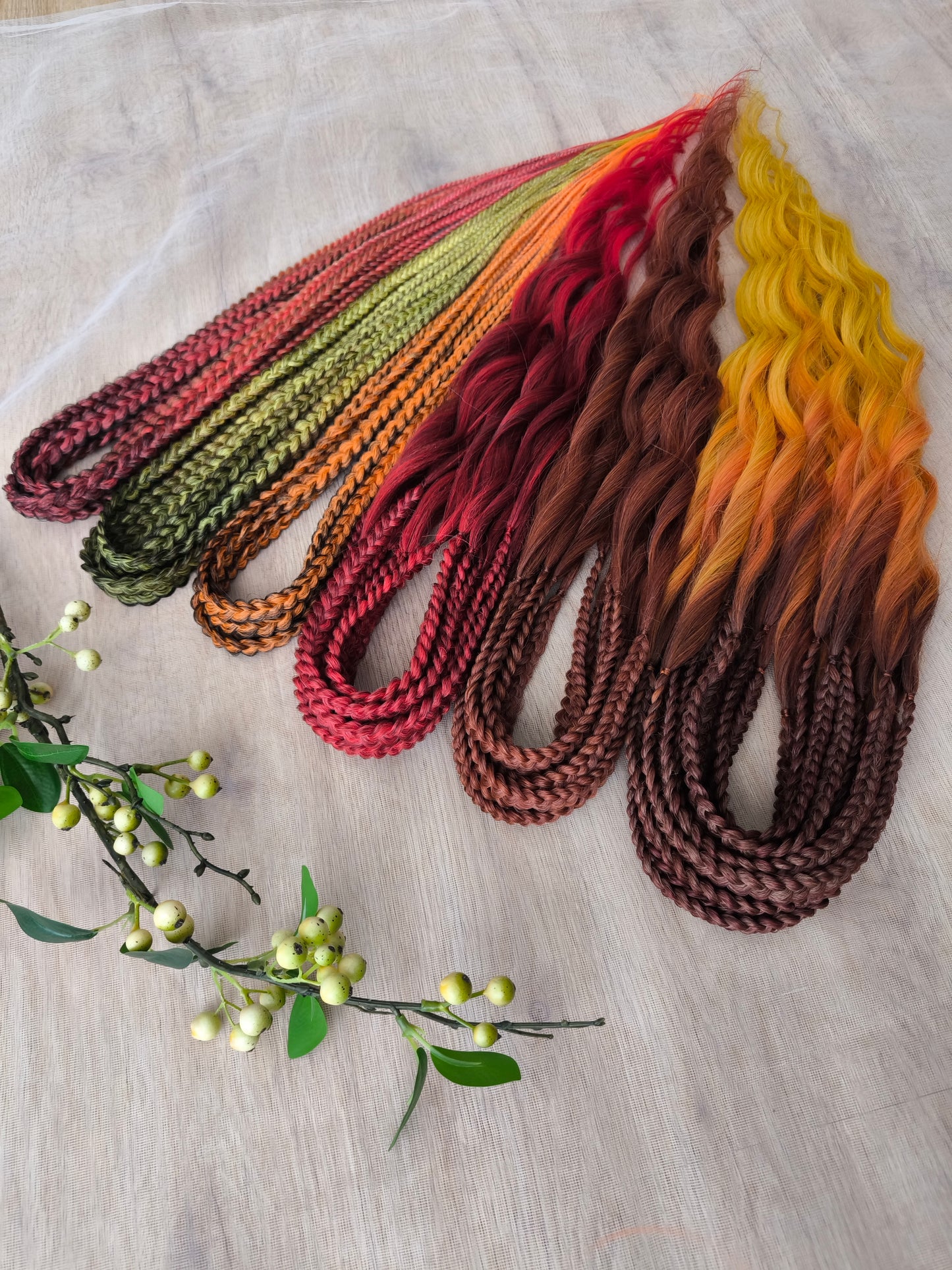 Mountain Sunrise: soft, lightweight, and reusable 55 double-ended synthetic braids with loose wavy brushable ends in red, bronze, yellow, and orange colors.