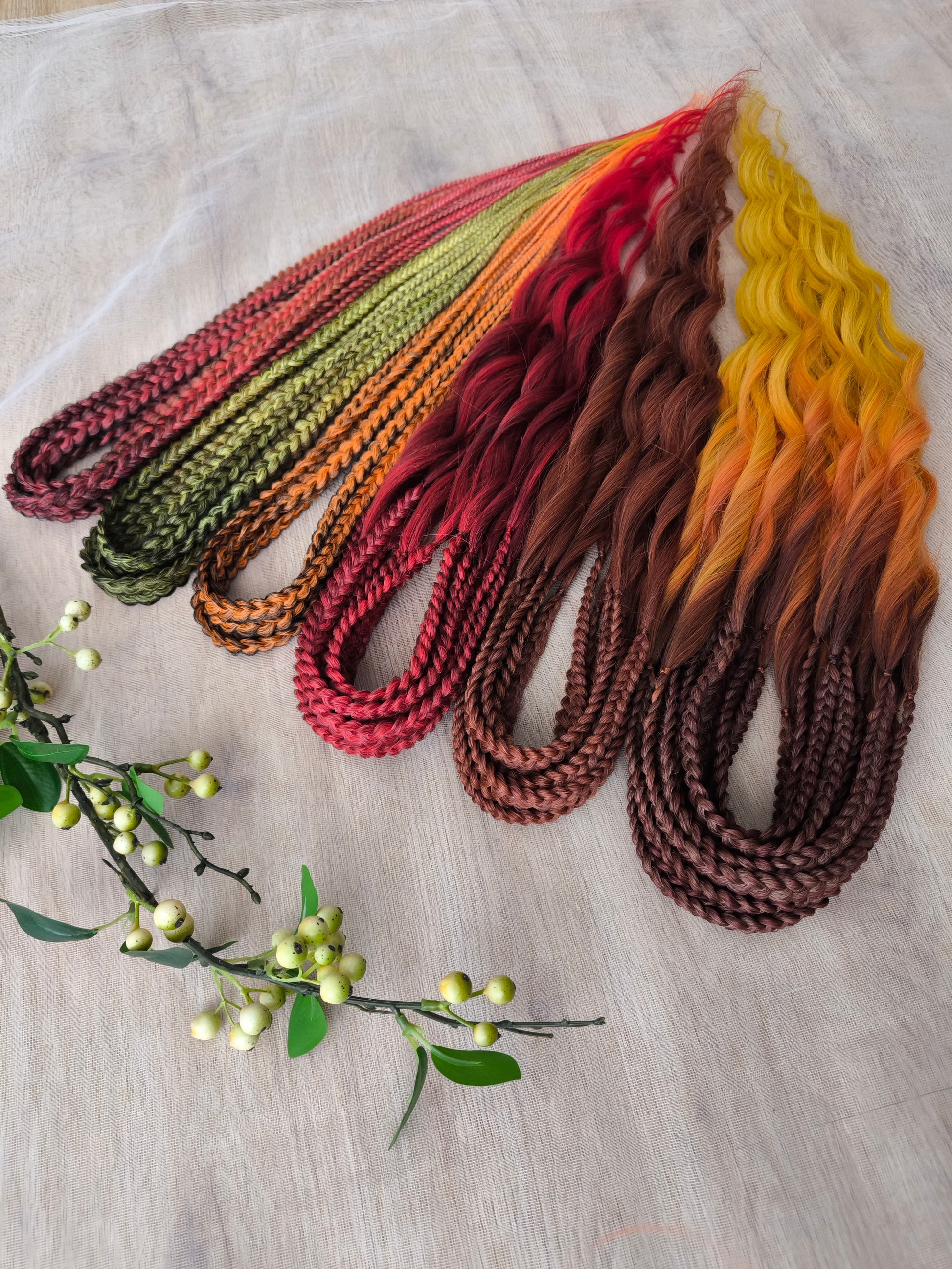 Mountain Sunrise: soft, lightweight, and reusable 55 double-ended synthetic braids with loose wavy brushable ends in red, bronze, yellow, and orange colors.