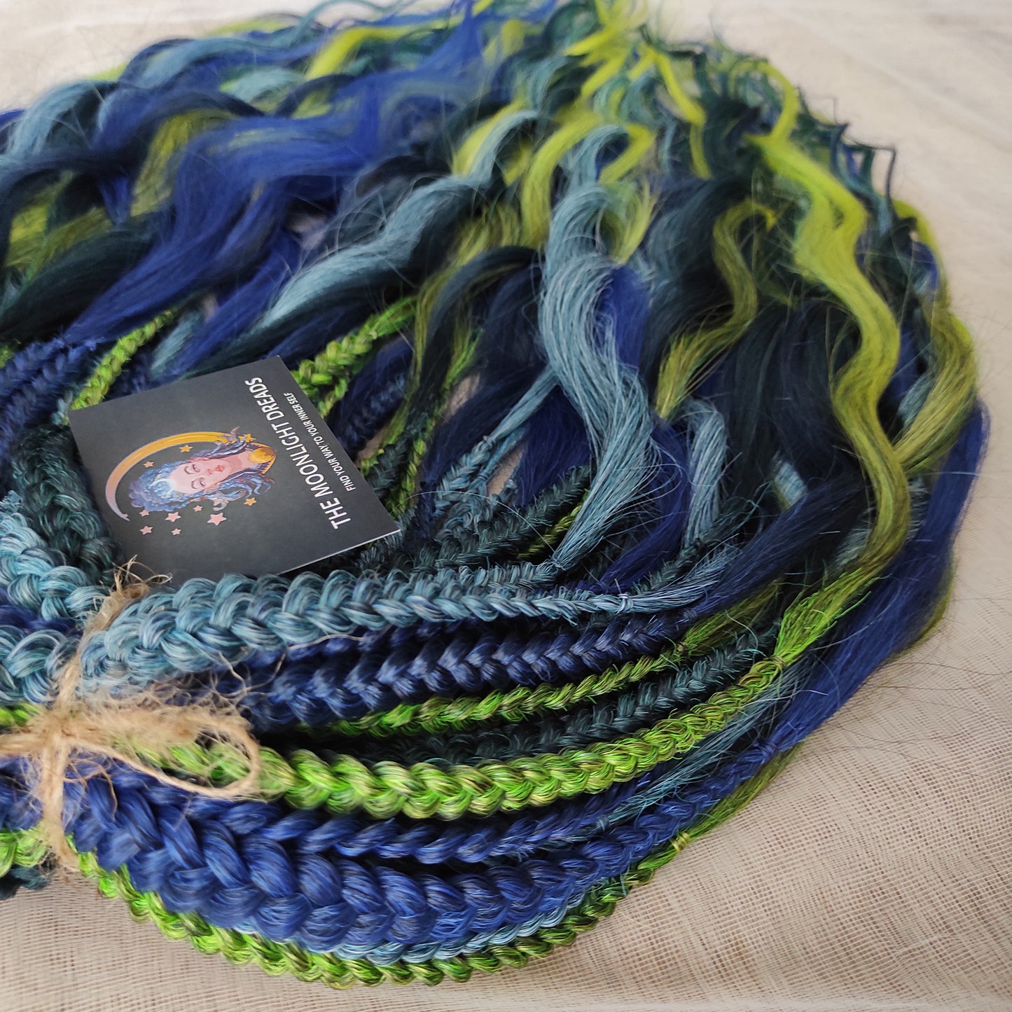 Inspired by the feathers of a peacock and the magic of the deep forest, this set blends rich navy, electric blue, moss green, lime, and seafoam in an eye-catching gradient. Whether you're stepping into a festival or simply expressing your wild side, this look makes a powerful statement.
Soft, lightweight, and reusable synthetic brushable double ended wavy dreadlocks, a mix of Anna and Body wave with braided middle.