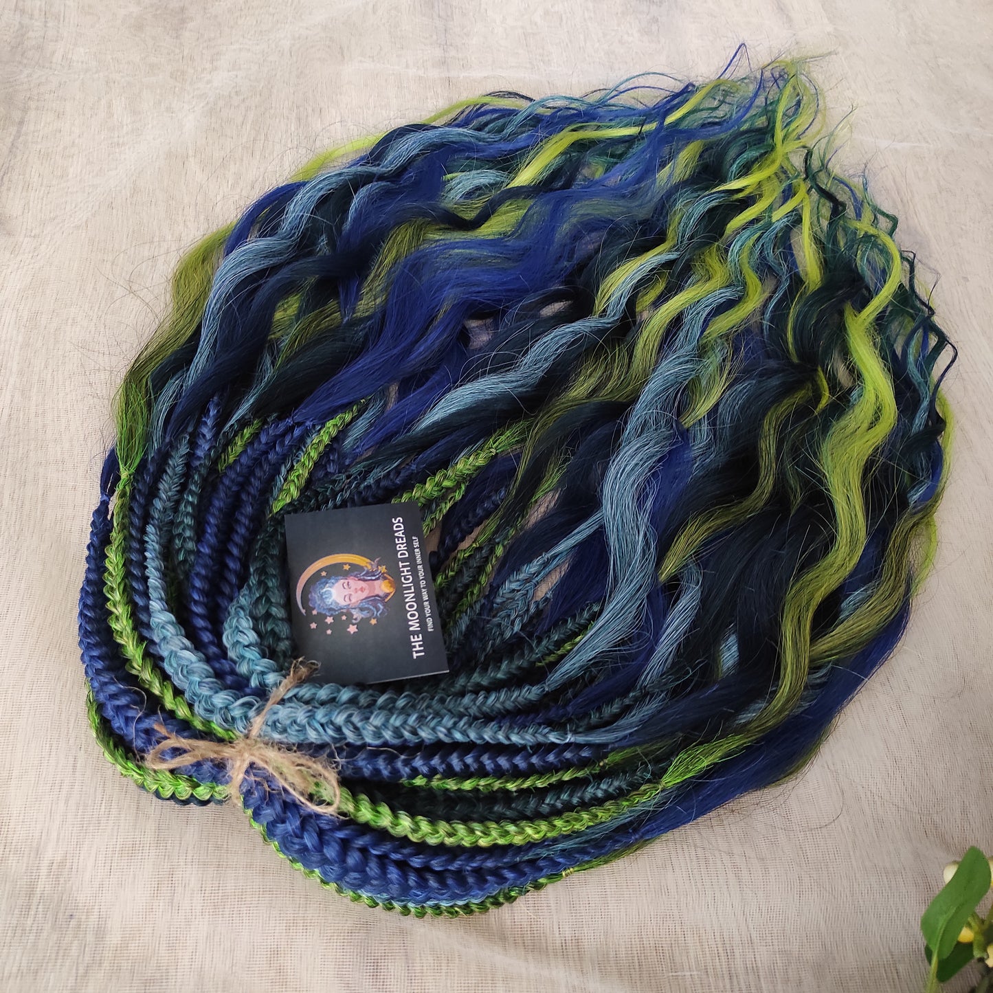 Inspired by the feathers of a peacock and the magic of the deep forest, this set blends rich navy, electric blue, moss green, lime, and seafoam in an eye-catching gradient. Whether you're stepping into a festival or simply expressing your wild side, this look makes a powerful statement.
Soft, lightweight, and reusable synthetic brushable double ended wavy dreadlocks, a mix of Anna and Body wave with braided middle.