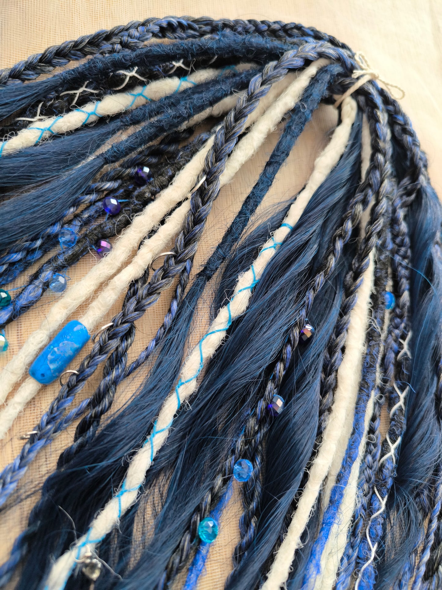 Deep blue see — navy blue, obmbre blue to blonde, and white partial set of 28 double ended synthetic dreadlocks, various braids, Senegalese twist, and brushable dreaded curls (decoration is included). Reusable lightweight set made from high-quality synthetic hypoallergenic material kanekalon.
Length: ±20-24 inches (50-60 cm)
Thickness of dreads and braids: ±0.6-0.8 cm
Dreaded part of curls ±3-4 inches (8-10 cm)
Weight with decoration: ±175 gr (6 oz)