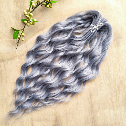 Frost Grey (steel blue) is a calm, elegant blend of silver and soft grey tones with a subtle lavender undertone. It reflects light beautifully, creating a silky, frosted look that feels both minimalistic and mystical. Soft, lightweight, and reusable synthetic brushable double ended wavy dreadlocks (regular dreaded, braided middle, or push-up). 