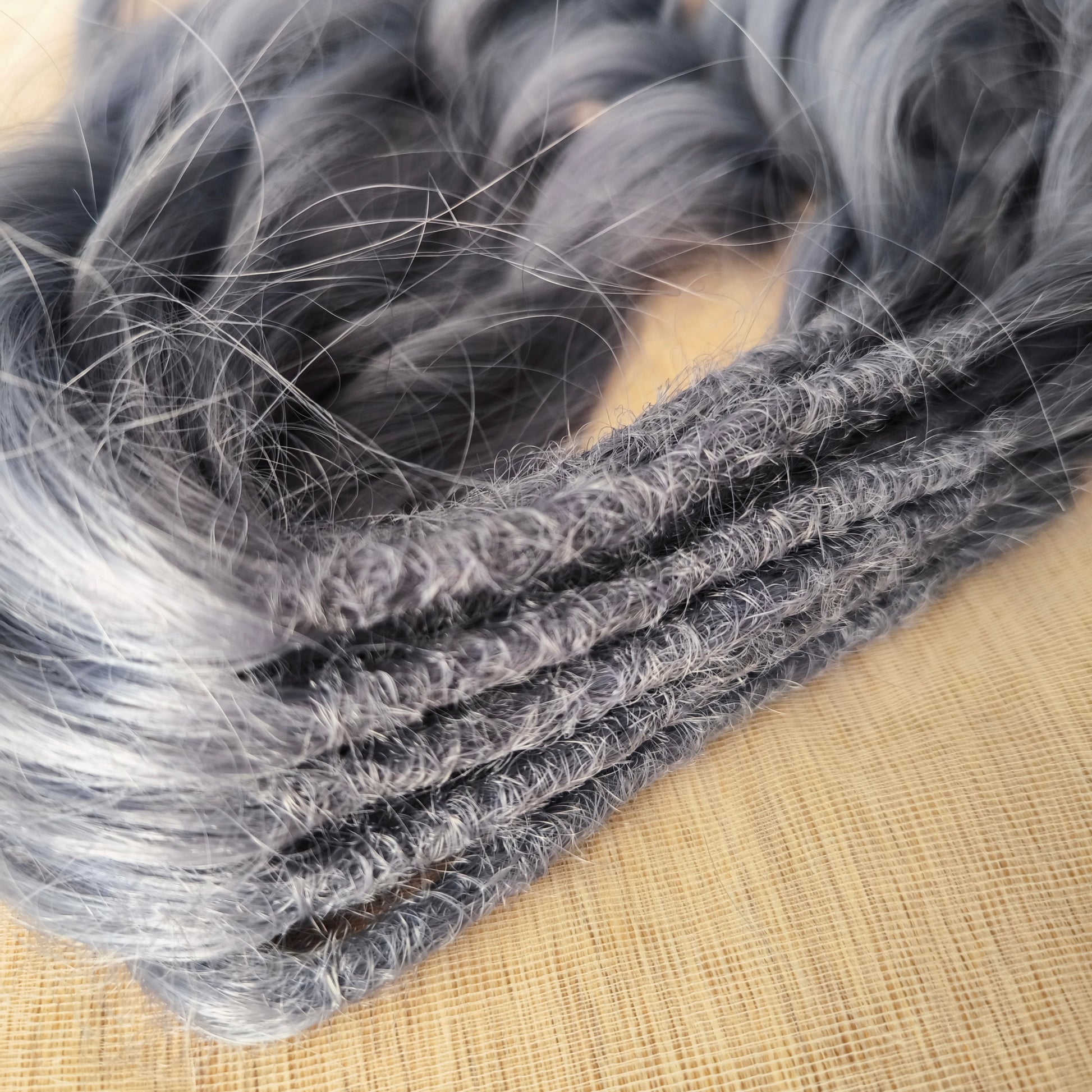 Frost Grey (steel blue) is a calm, elegant blend of silver and soft grey tones with a subtle lavender undertone. It reflects light beautifully, creating a silky, frosted look that feels both minimalistic and mystical. Soft, lightweight, and reusable synthetic brushable double ended wavy dreadlocks (regular dreaded, braided middle, or push-up). 