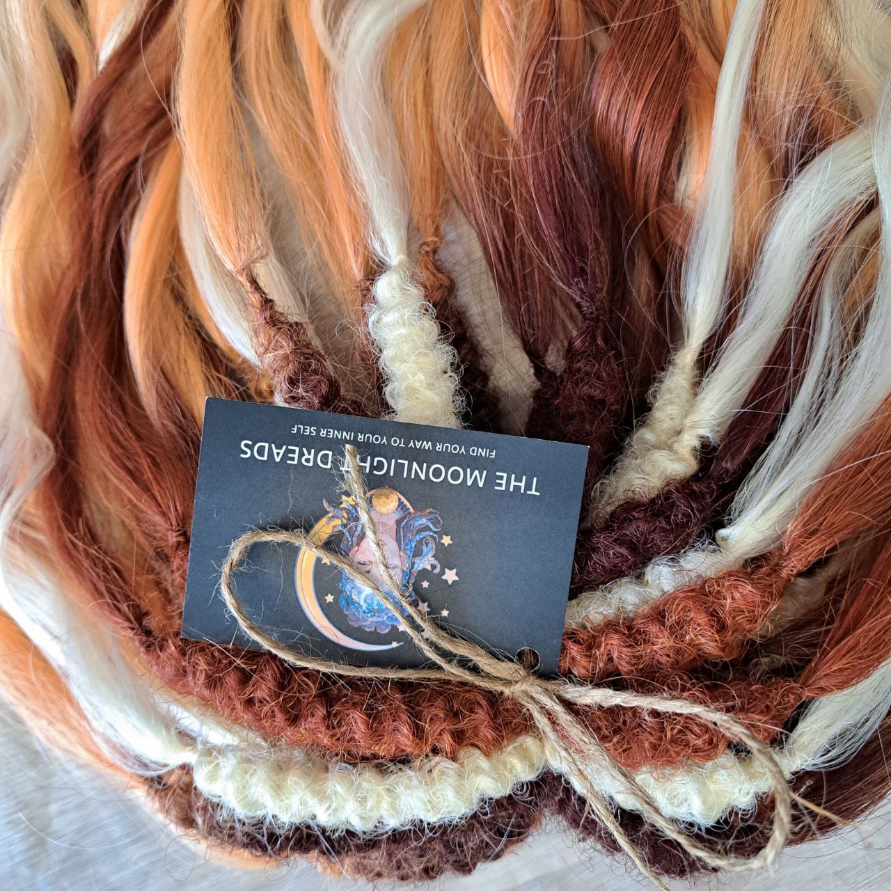 This set combines a rich three-tone ombré gradient — deep chestnut, warm copper, and pale blonde — with additional solid strands in copper and creamy platinum, creating a stunning play of light and color.
Inspired by autumn leaves, glowing embers, and the graceful energy of a wild fox, Amber Fox is made to stand out with both softness and strength.
Soft, lightweight, and reusable synthetic brushable double ended wavy dreadlocks (available as regular dreaded, braided middle, or push-up).