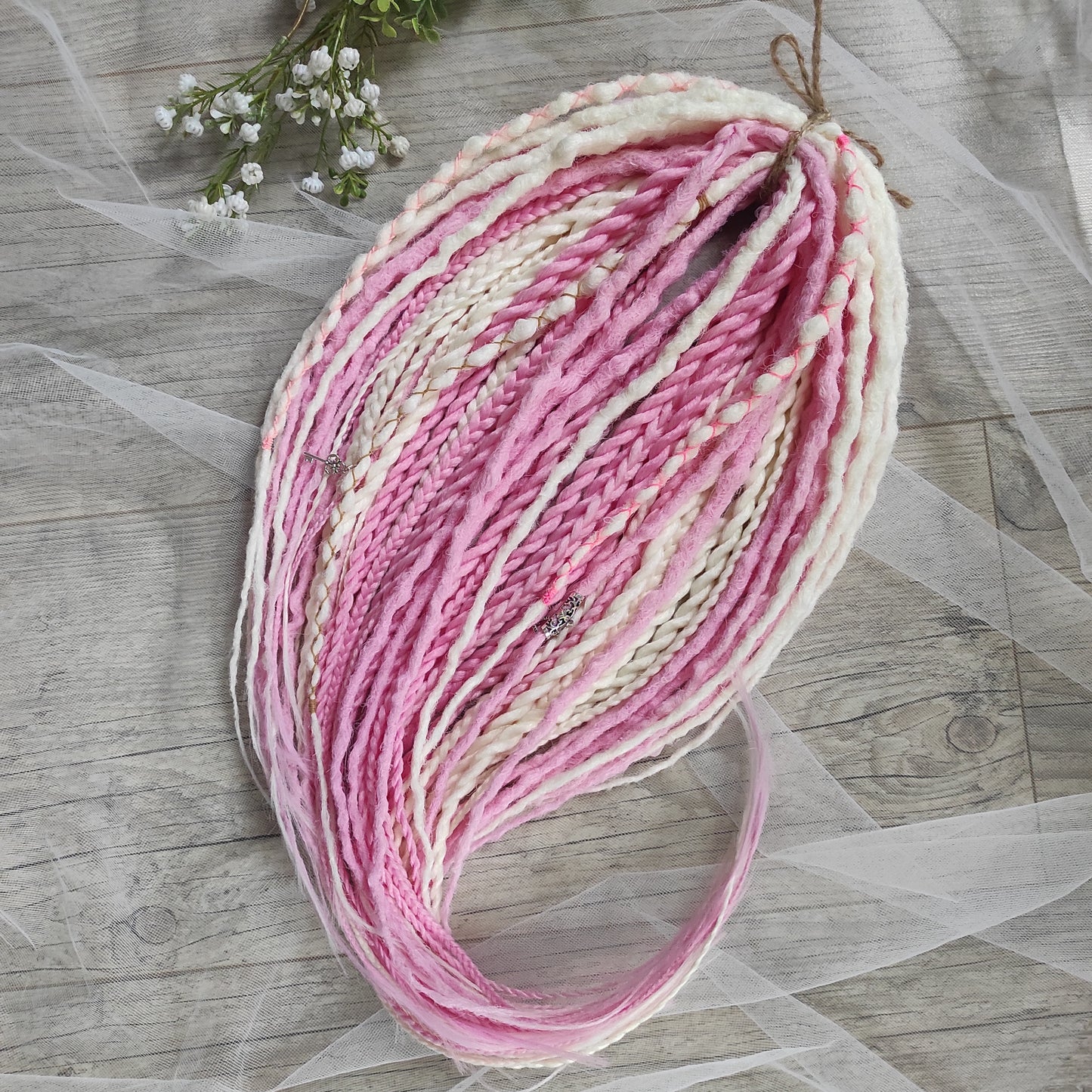 A soft blend of creamy white and gentle pink tones double ended crochet bumpy dreads, braids, and Senegalese twists. Decoration is included. Reusable lightweight set made from high-quality synthetic hypoallergenic material kanekalon.

Standard length: ±22-24 inches (55-60 cm)
Thickness of dreads and braids: ±0.8 cm