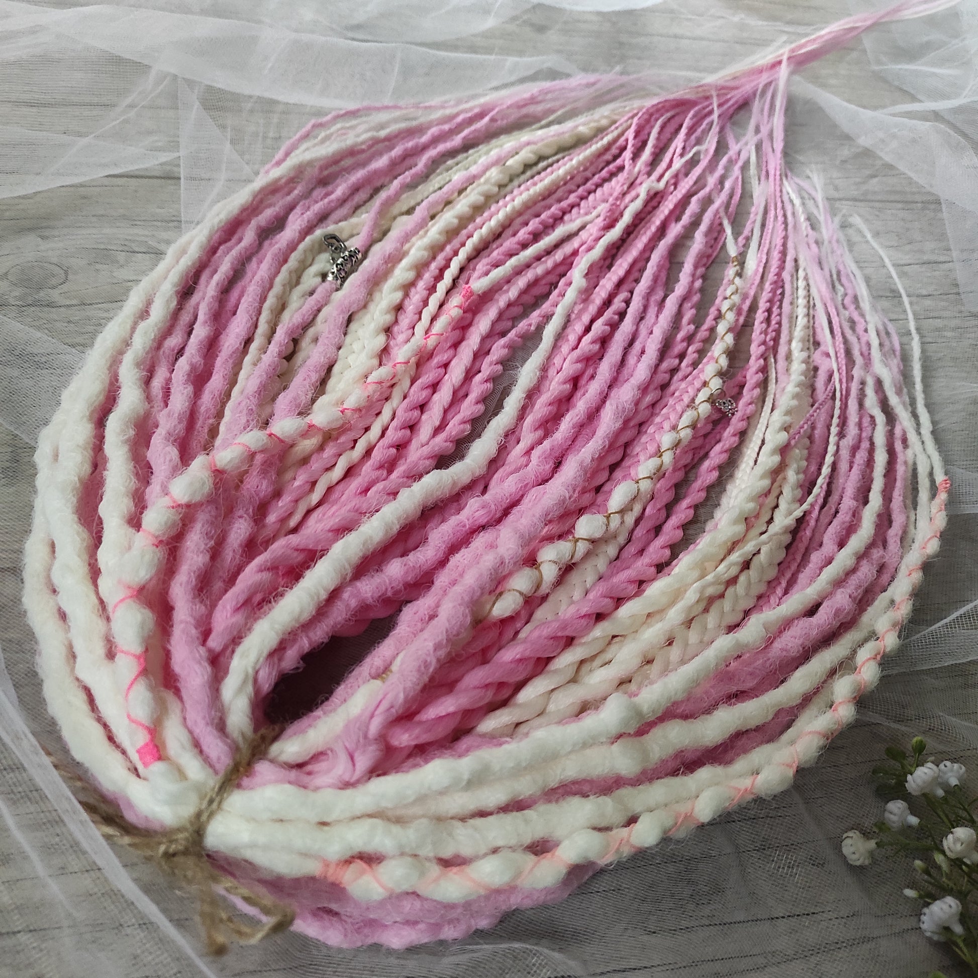 A soft blend of creamy white and gentle pink tones double ended crochet bumpy dreads, braids, and Senegalese twists. Decoration is included. Reusable lightweight set made from high-quality synthetic hypoallergenic material kanekalon.

Standard length: ±22-24 inches (55-60 cm)
Thickness of dreads and braids: ±0.8 cm