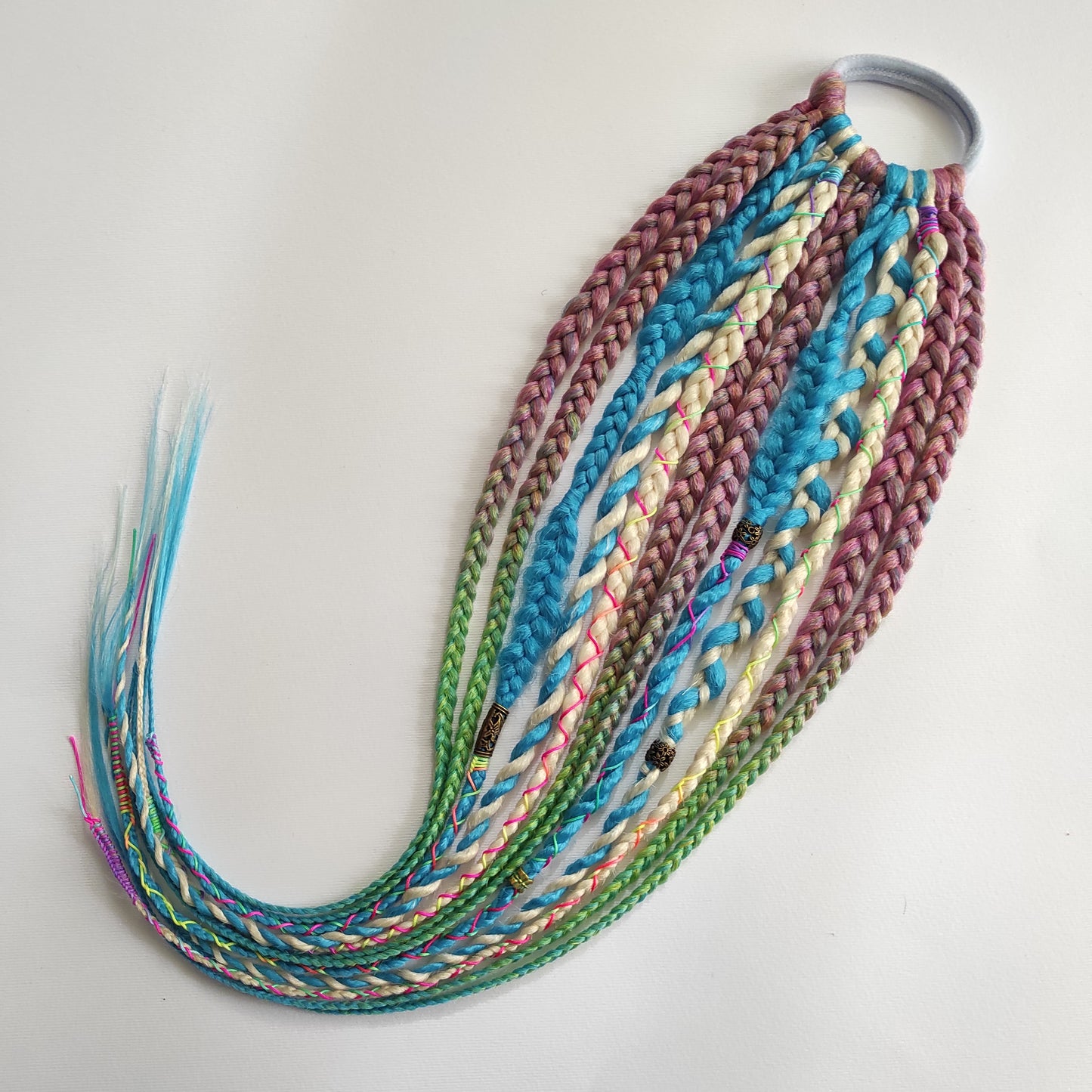Braids, dreads, and curls on an elastic band — a simple way to transform a ponytail without installing a set. Easy to put on and remove whenever you like. A great option if you can’t install dreads or braids. Also, a perfect gift for kids 🎁

These scrunchies add instant length, volume, and texture — whether you prefer bold colors or natural shades.

Length: 22–24 inches.
Each hair tie includes 12–14 pieces, depending on the style.

Choose from the available designs shown, or contact us for a custom order.
