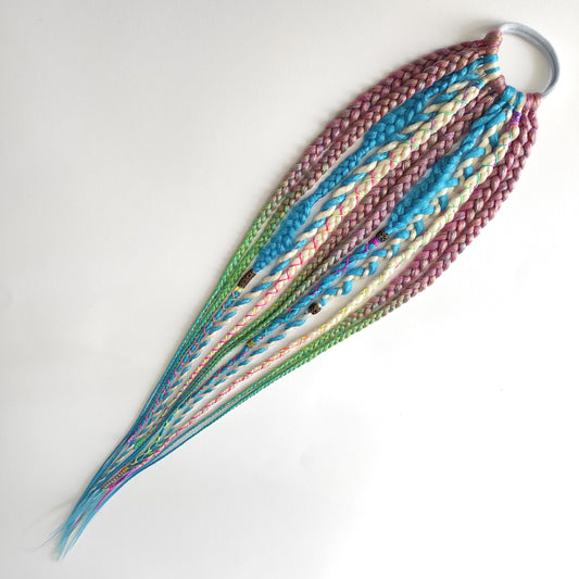 Braids, dreads, and curls on an elastic band — a simple way to transform a ponytail without installing a set. Easy to put on and remove whenever you like. A great option if you can’t install dreads or braids. Also, a perfect gift for kids 🎁

These scrunchies add instant length, volume, and texture — whether you prefer bold colors or natural shades.

Length: 22–24 inches.
Each hair tie includes 12–14 pieces, depending on the style.

Choose from the available designs shown, or contact us for a custom order.