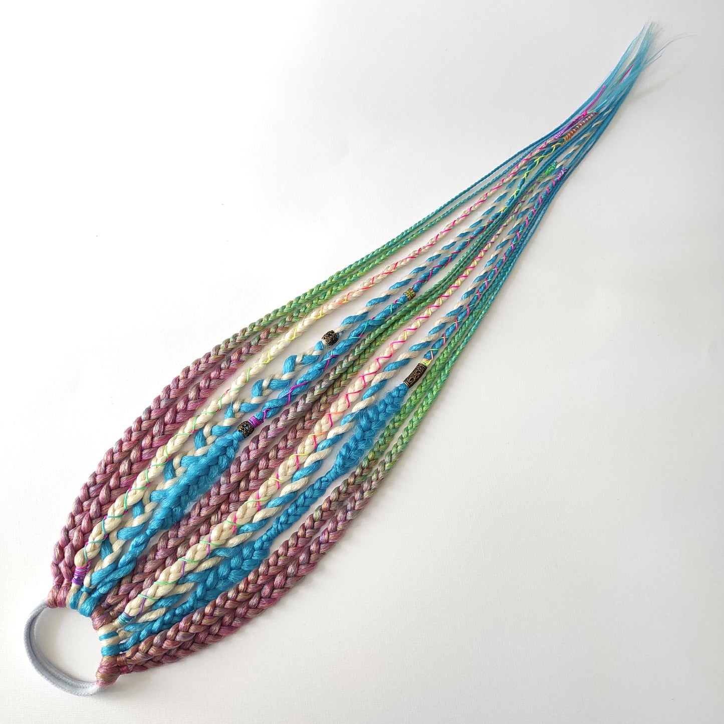Braids, dreads, and curls on an elastic band — a simple way to transform a ponytail without installing a set. Easy to put on and remove whenever you like. A great option if you can’t install dreads or braids. Also, a perfect gift for kids 🎁

These scrunchies add instant length, volume, and texture — whether you prefer bold colors or natural shades.

Length: 22–24 inches.
Each hair tie includes 12–14 pieces, depending on the style.

Choose from the available designs shown, or contact us for a custom order.