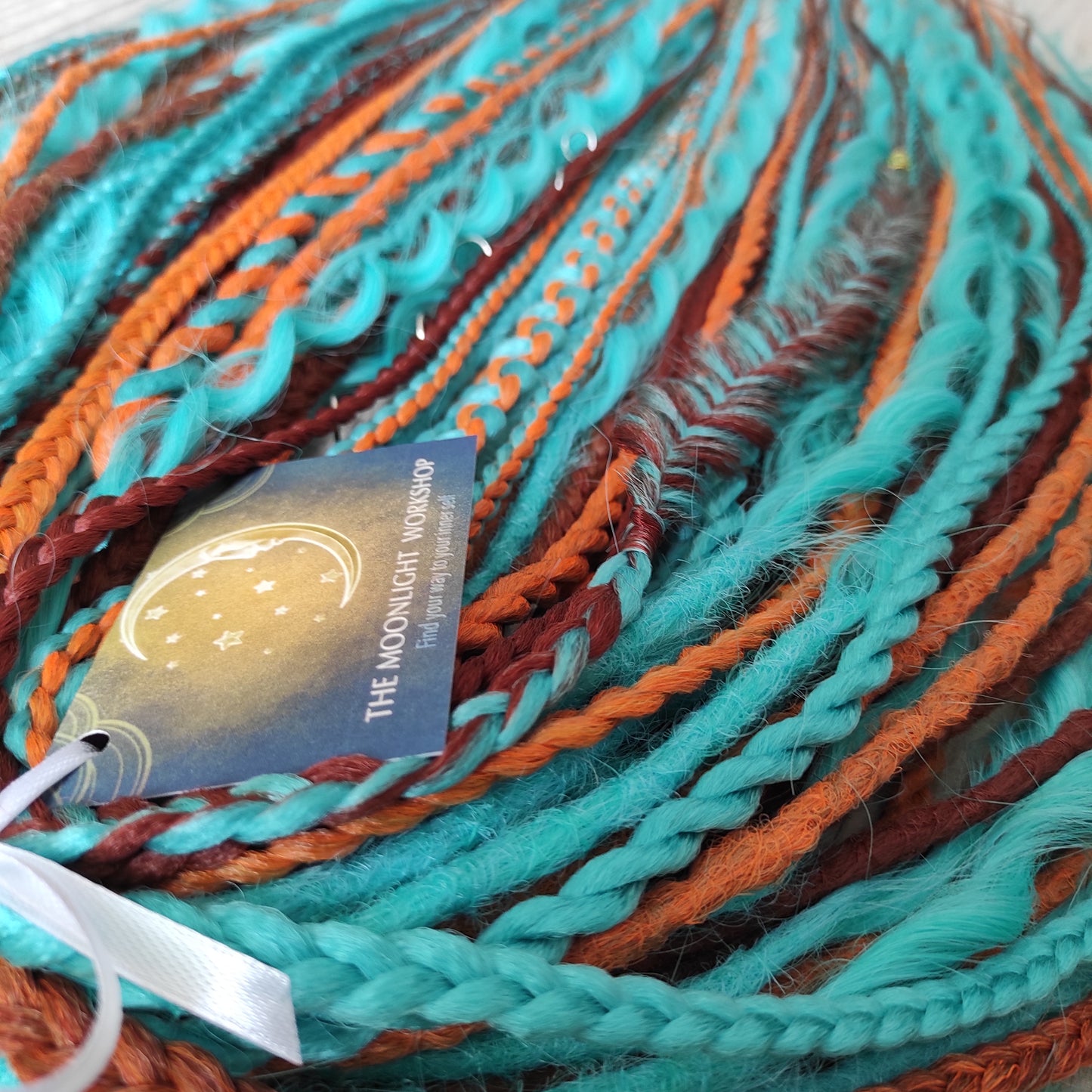 Ginger Sky: soft, lightweight, and reusable double ended synthetic dreads, braids, and regular dreaded non-brushable curls. A mix of turquoise green, red, copper, and orange colours.

The length is 22-24 inches (55-60 cm)
Dreaded part of curls: 3-4 inches
Thickness of dreads and braids ±0.8 cm