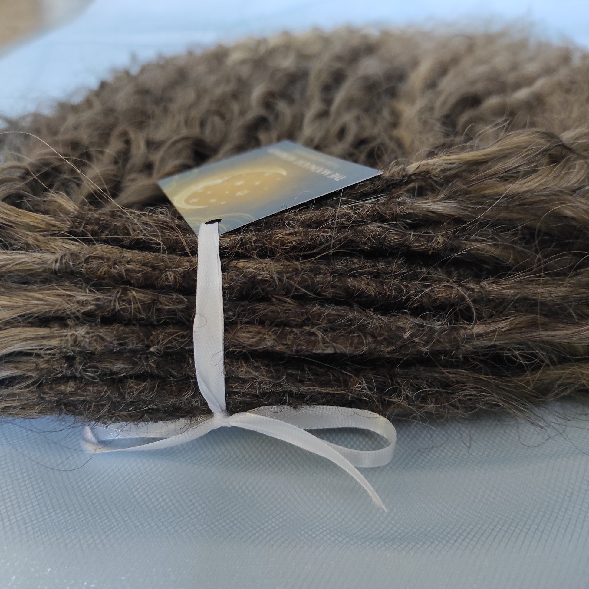 Ash ombre from light brown to wheat blonde (the color may look a bit different in different lighting). Soft, lightweight, and reusable synthetic brushable double ended wavy dreadlocks