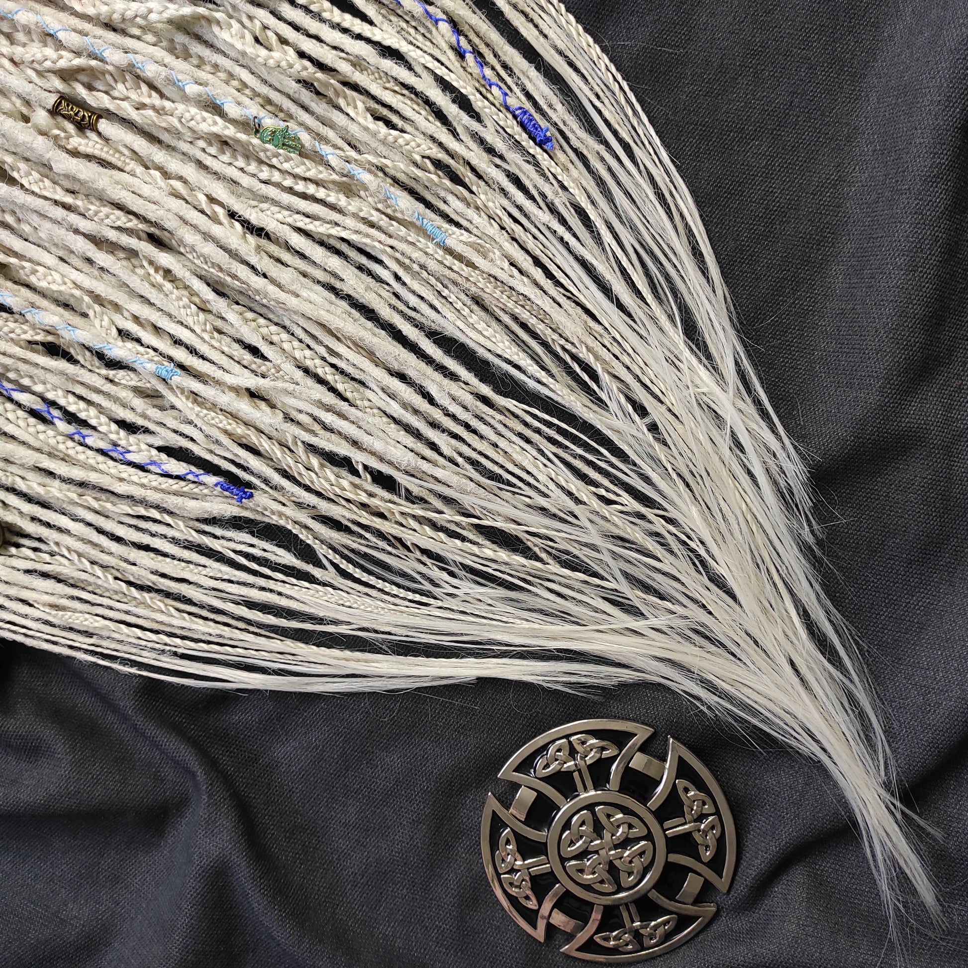 This set of synthetic dreadlocks combines elements of a Viking-inspired aesthetic.
Scandinavian blonde double ended crochet bumpy dreads, braids, and Senegalese twists. Decoration is included. Reusable lightweight set made from high-quality synthetic hypoallergenic material kanekalon.

Standard length: ±22-24 inches (55-60 cm)
Thickness of dreads and braids: ±0.8 cm