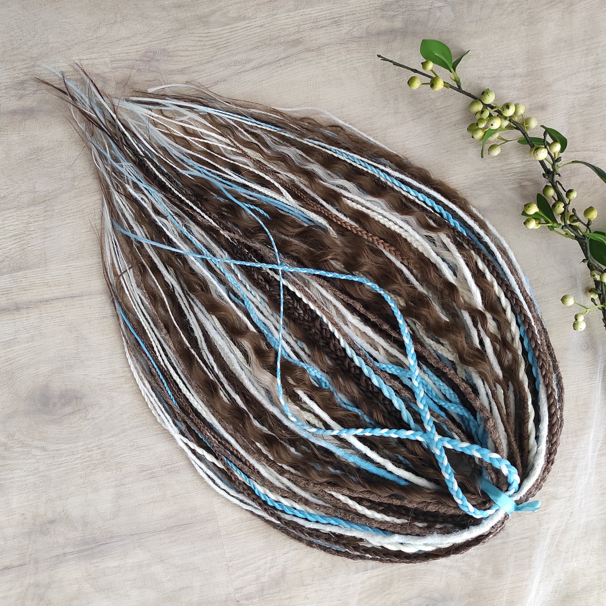 A calm mix of cocoa brown, creamy blonde, and bright blue accents — lightweight, brushable, and reusable synthetic DE curls and braids.