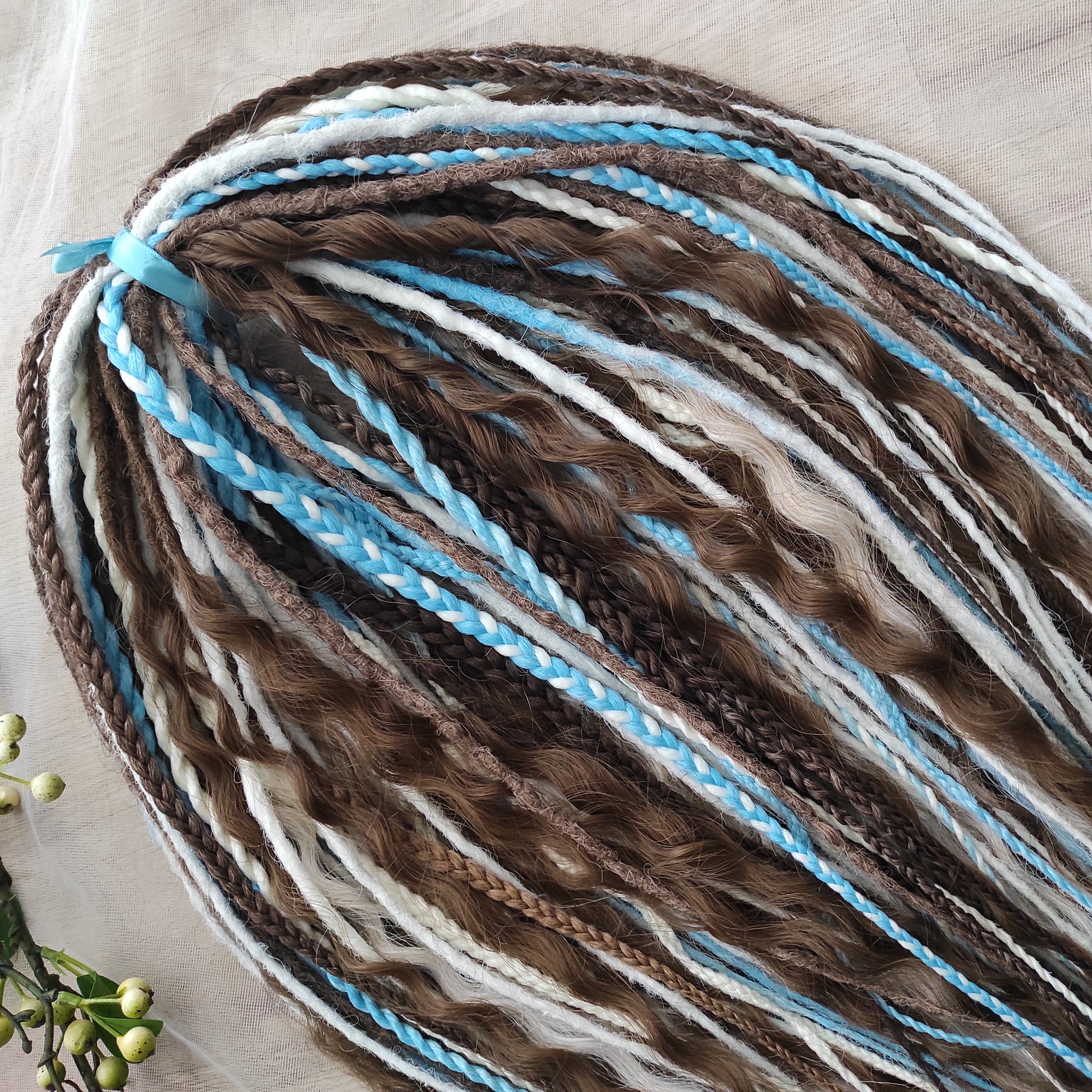A calm mix of cocoa brown, creamy blonde, and bright blue accents — lightweight, brushable, and reusable synthetic DE curls and braids.