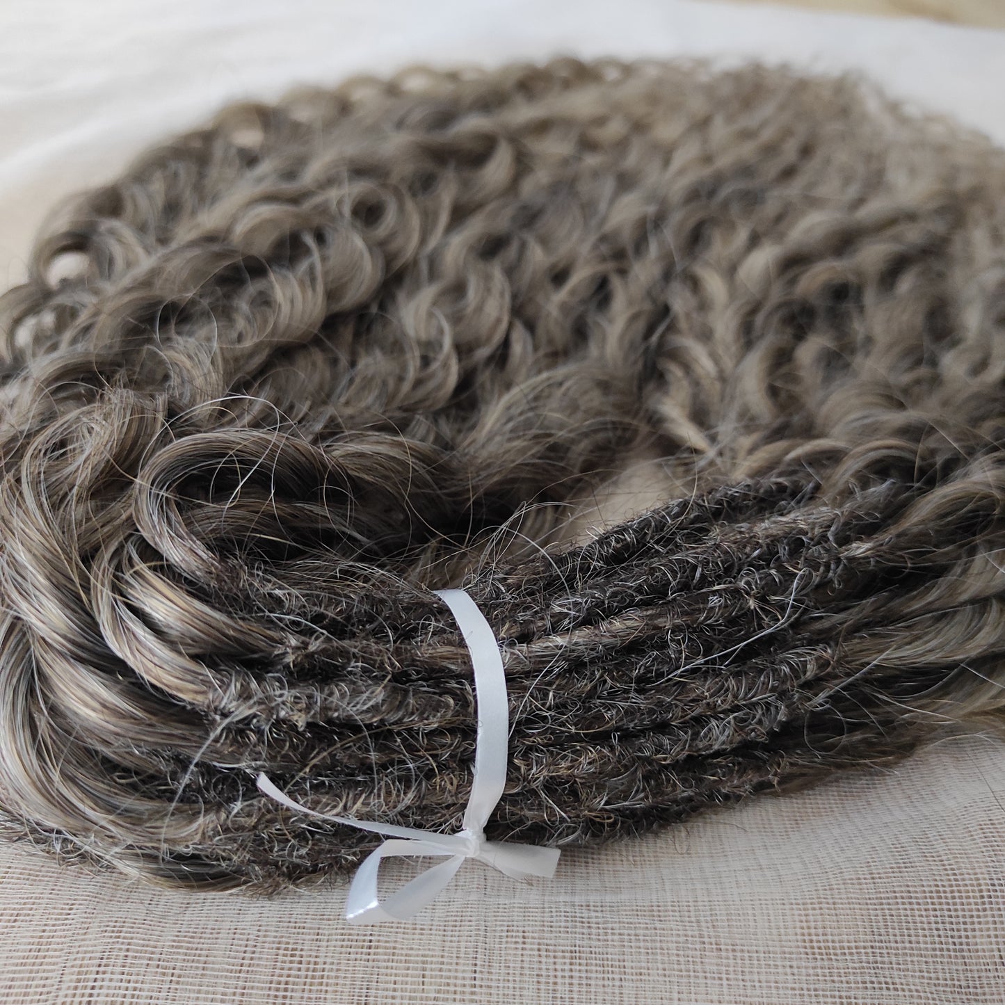 Ash ombre from light brown to wheat blonde (the color may look a bit different in different lighting). Soft, lightweight, and reusable synthetic brushable double ended wavy dreadlocks