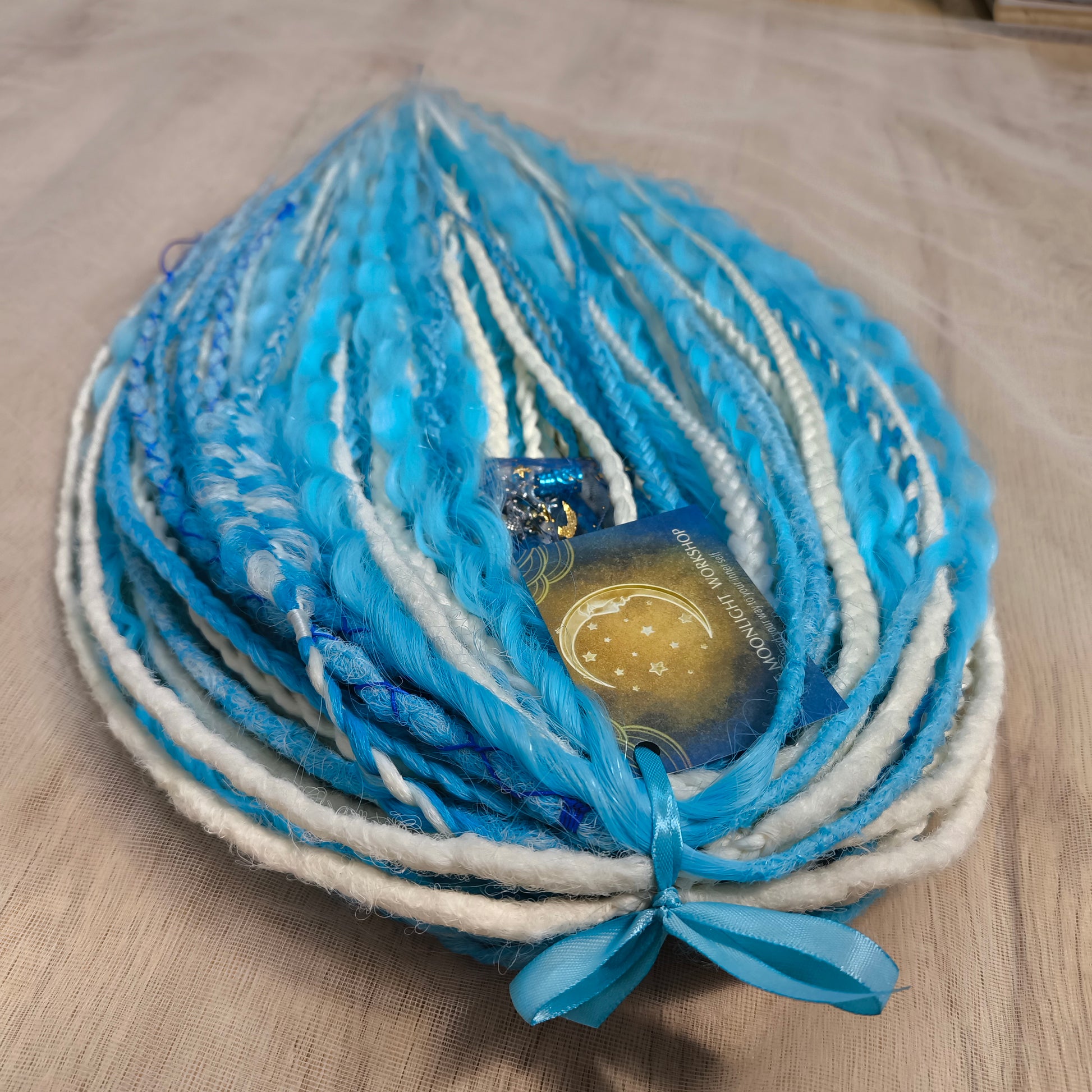 Ice Flow is a soft, lightweight, and reusable set of double ended synthetic crochet dreadlocks, various braids, and dreaded curls. A fresh blend of icy blue and soft white with a smooth, airy flow of color.

Standard length: 22-24 inches (55-60 cm)
Thickness of dreads and braids: ~0.8 cm
Dreaded part of curls ~3-4 inches (8-10 cm)