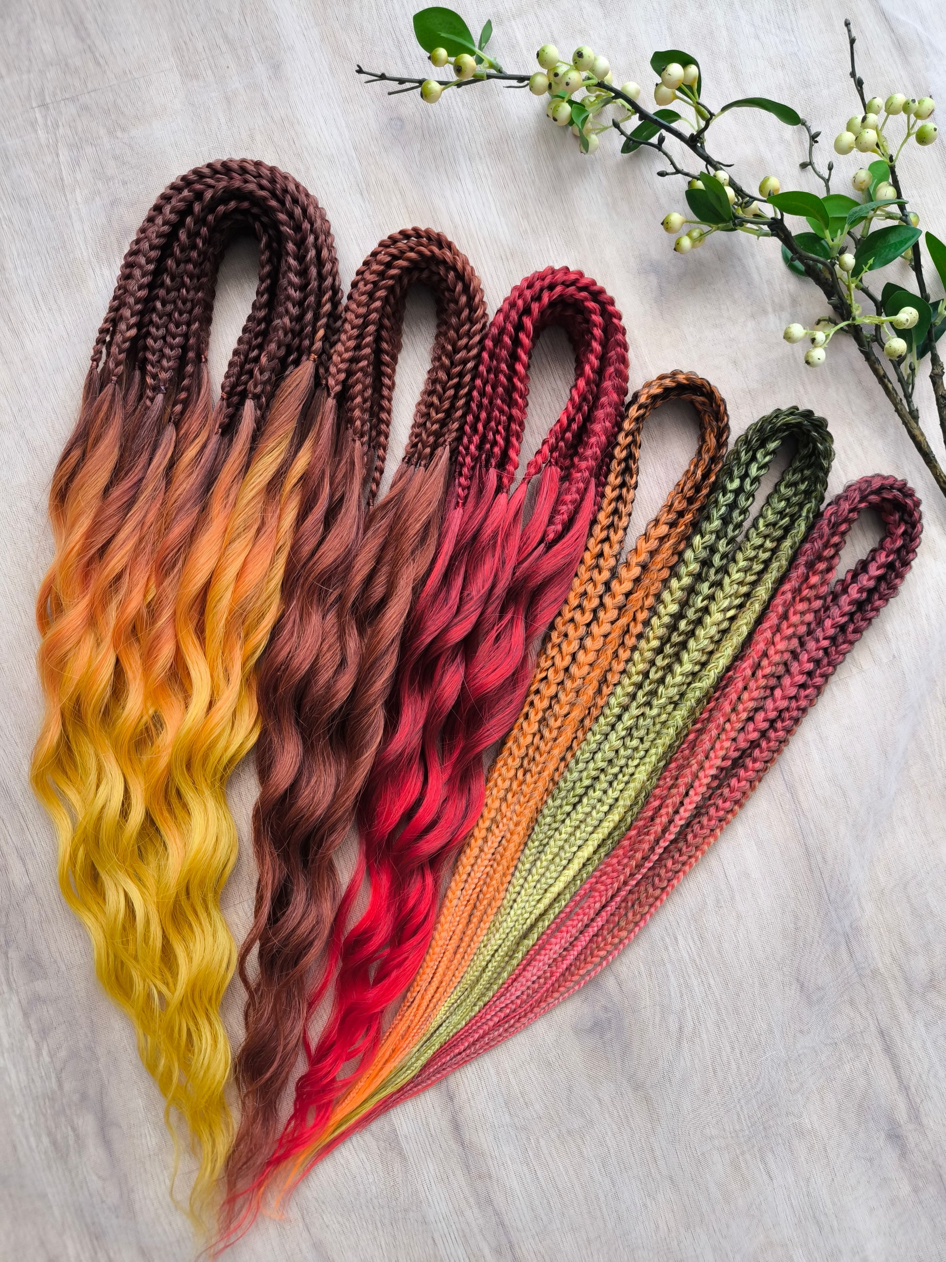 Mountain Sunrise: soft, lightweight, and reusable 55 double-ended synthetic braids with loose wavy brushable ends in red, bronze, yellow, and orange colors.