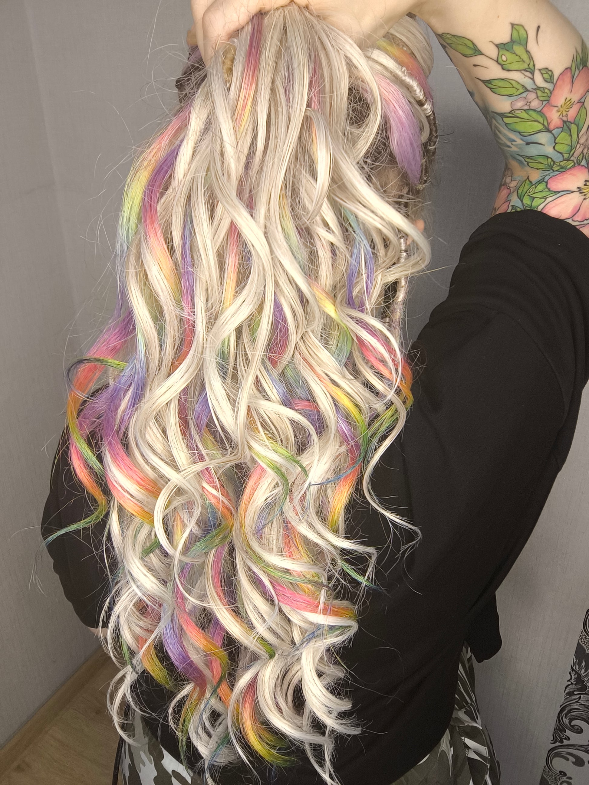 White Rainbow - 60 DE soft, lightweight, and reusable synthetic standard dreaded brushable curls Manasi. Platinum blonde base blended with rainbow/prism/glitch effect accents. 

Length: 16 inches (40 cm)
Dreaded part: approximately 3-4 inches (8-10 cm)
Weight: ±300 gr (10,6 oz)
