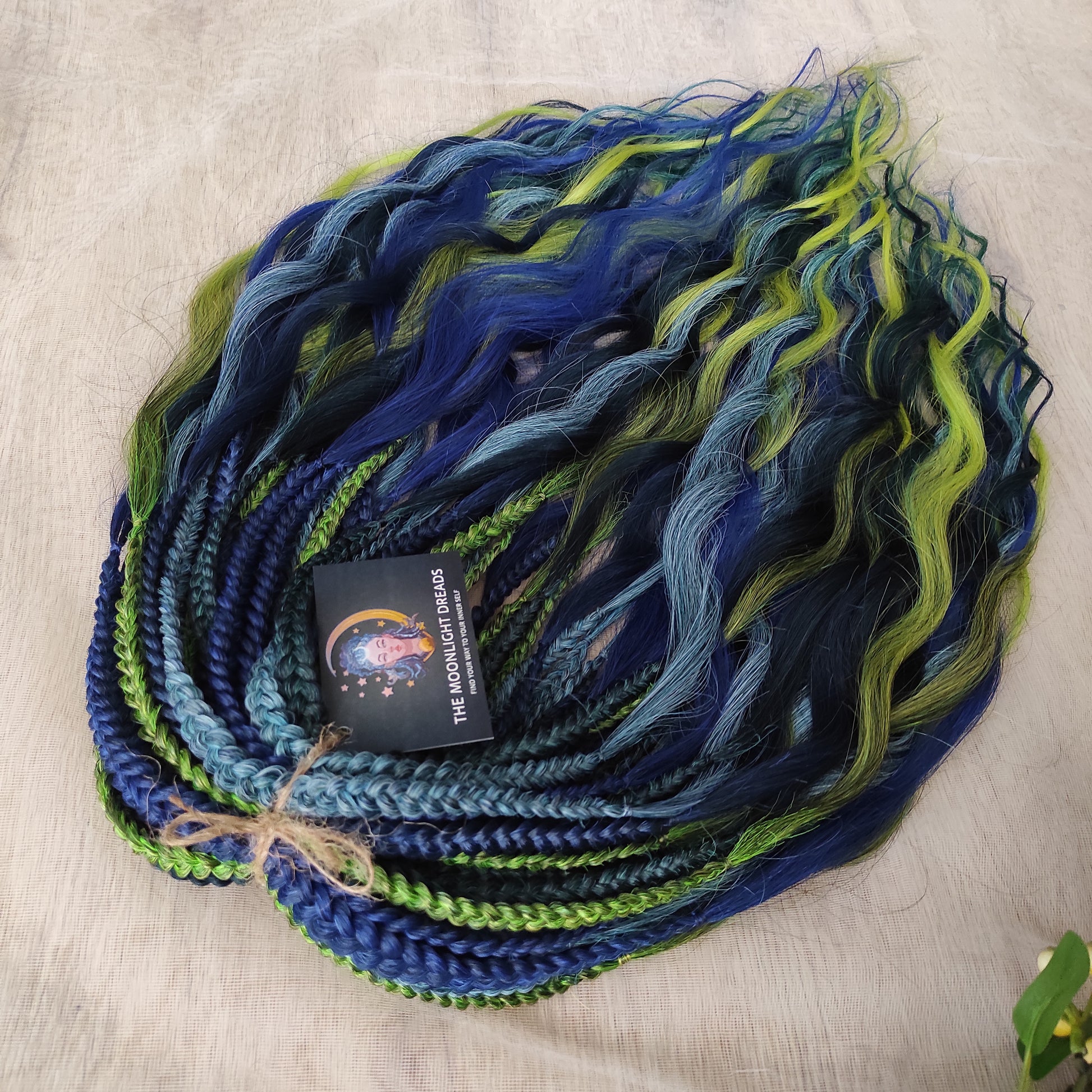 Inspired by the feathers of a peacock and the magic of the deep forest, this set blends rich navy, electric blue, moss green, lime, and seafoam in an eye-catching gradient. Whether you're stepping into a festival or simply expressing your wild side, this look makes a powerful statement.

Soft, lightweight, and reusable synthetic brushable double ended wavy dreadlocks, a mix of Anna and Body wave with braided middle.