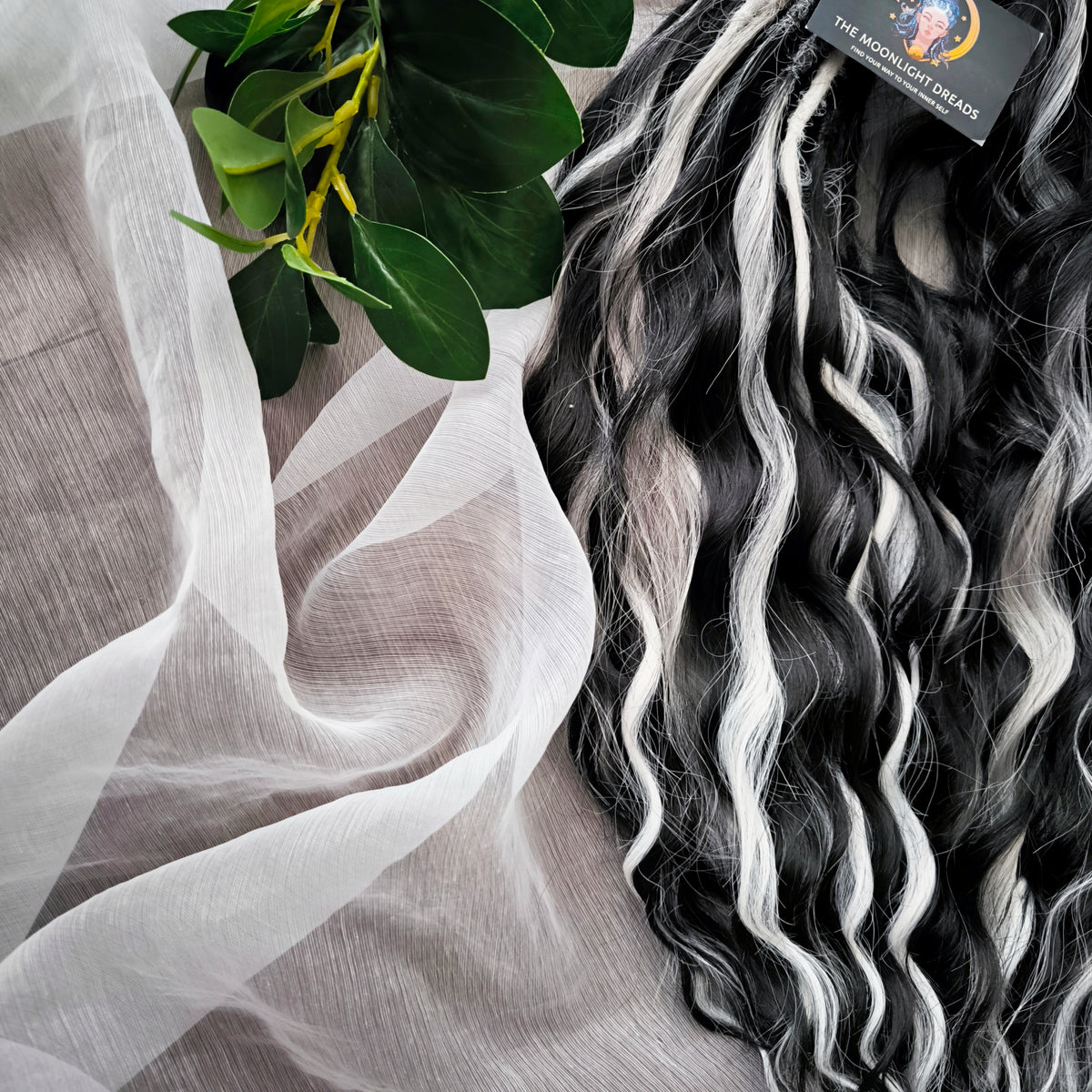 Silver Raven - 50 double ended ready-to-ship black, silver-grey, and white synthetic brushable wavy dreadlocks. Soft, lightweight, and reusable, a monochromatic blend with a dark, mysterious, witchy feel. Your spooky season look starts here
