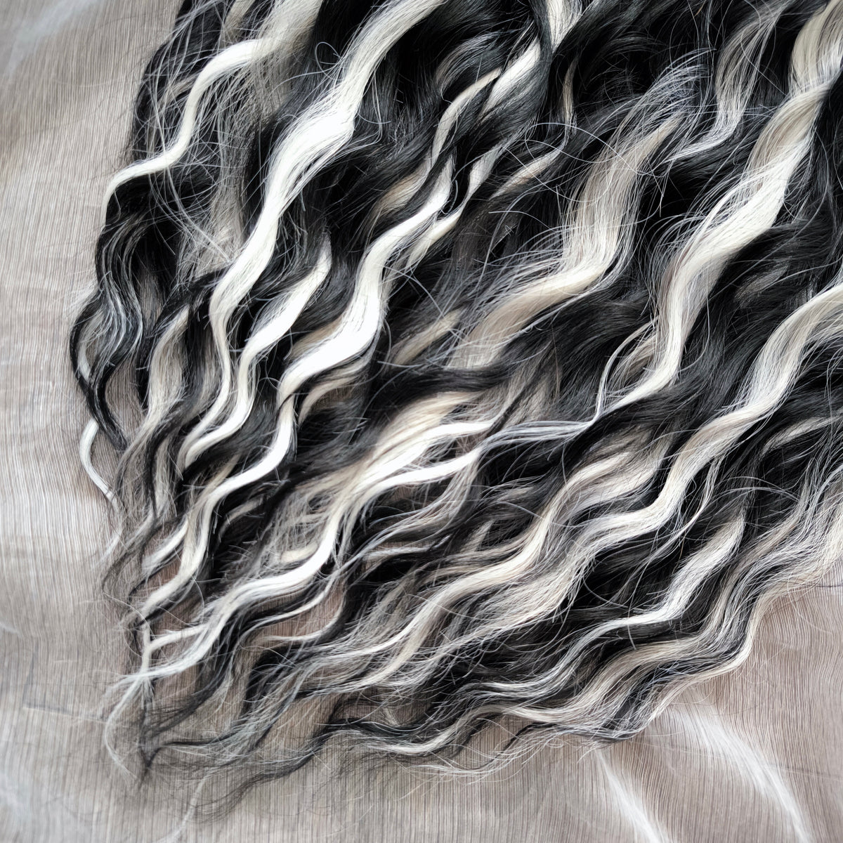 Silver Raven - 50 double ended ready-to-ship black, silver-grey, and white synthetic brushable wavy dreadlocks. Soft, lightweight, and reusable, a monochromatic blend with a dark, mysterious, witchy feel. Your spooky season look starts here
