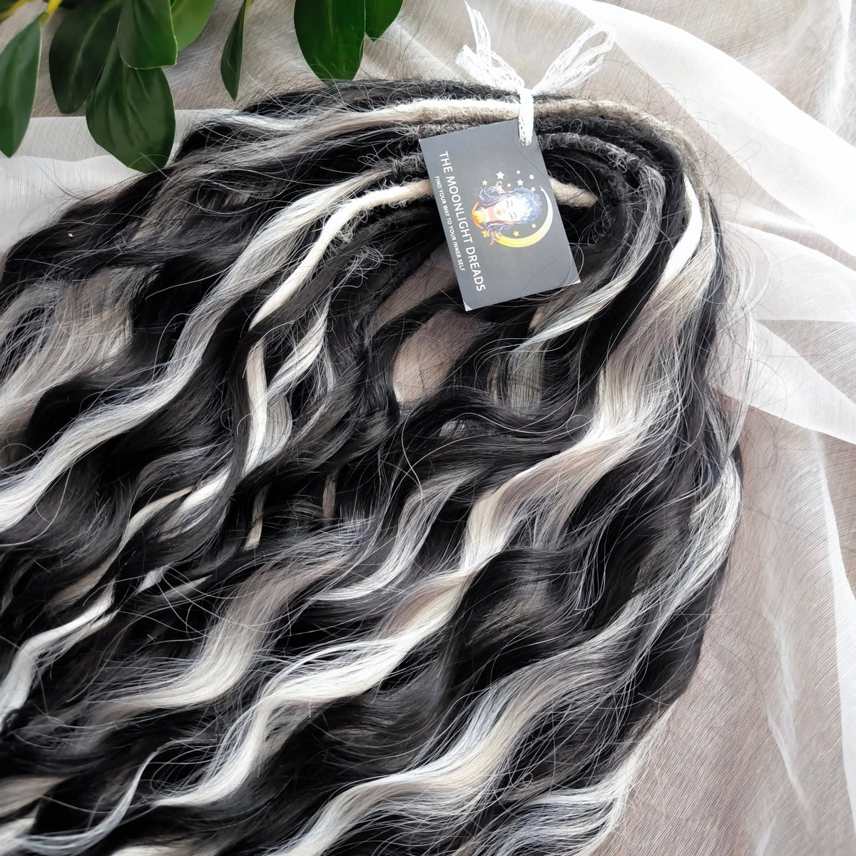 Silver Raven - 50 double ended ready-to-ship black, silver-grey, and white synthetic brushable wavy dreadlocks. Soft, lightweight, and reusable, a monochromatic blend with a dark, mysterious, witchy feel. Your spooky season look starts here
