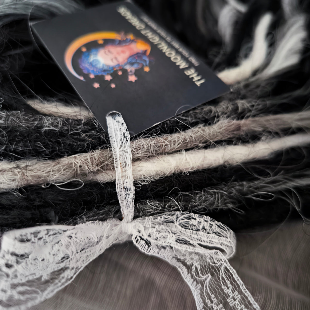 Silver Raven - 50 double ended ready-to-ship black, silver-grey, and white synthetic brushable wavy dreadlocks. Soft, lightweight, and reusable, a monochromatic blend with a dark, mysterious, witchy feel. Your spooky season look starts here
