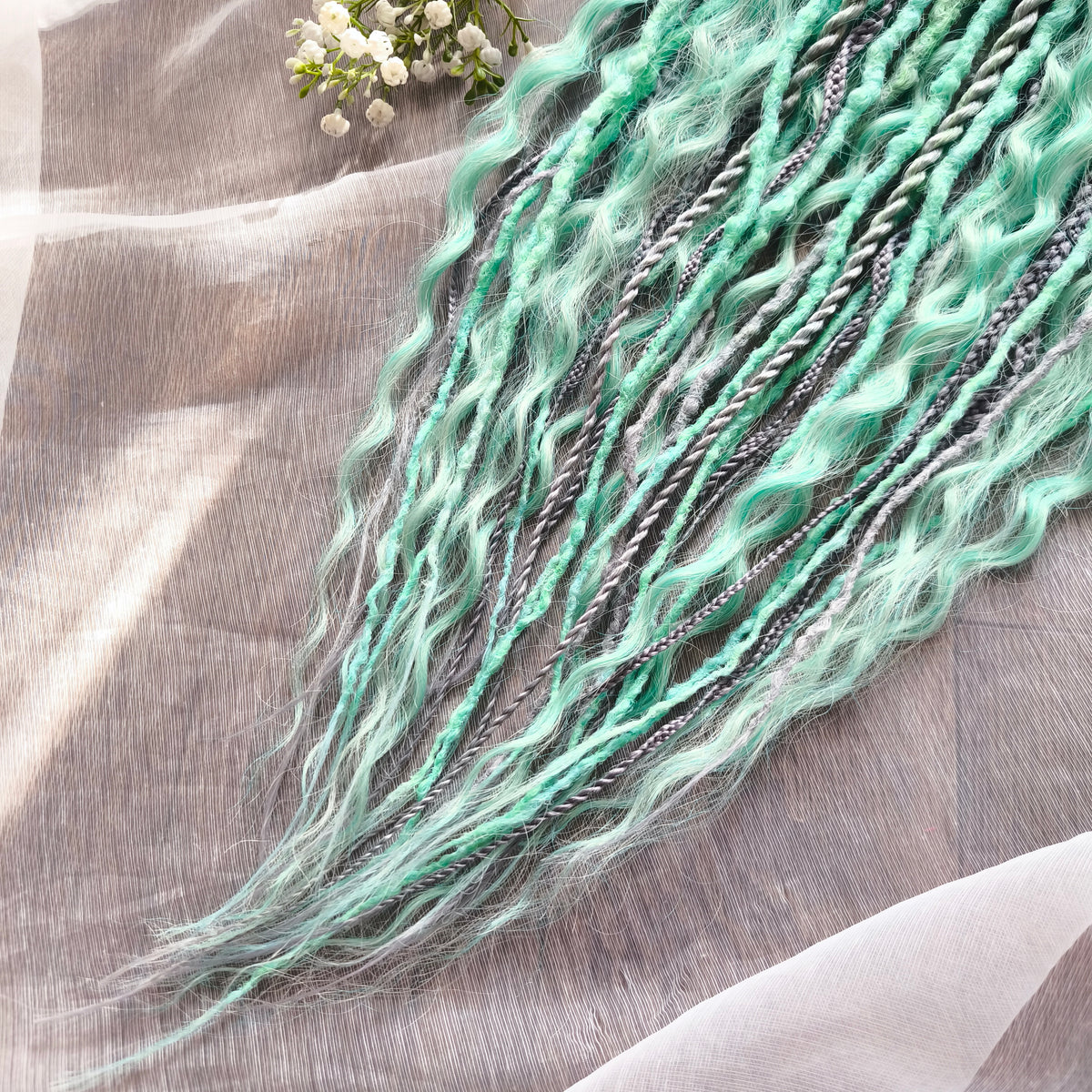 Silver Mint: soft, lightweight, and reusable 20 double ended synthetic crochet dreadlocks, braids, and non-brushable curls in a soft blend of silver and aquamarine.
