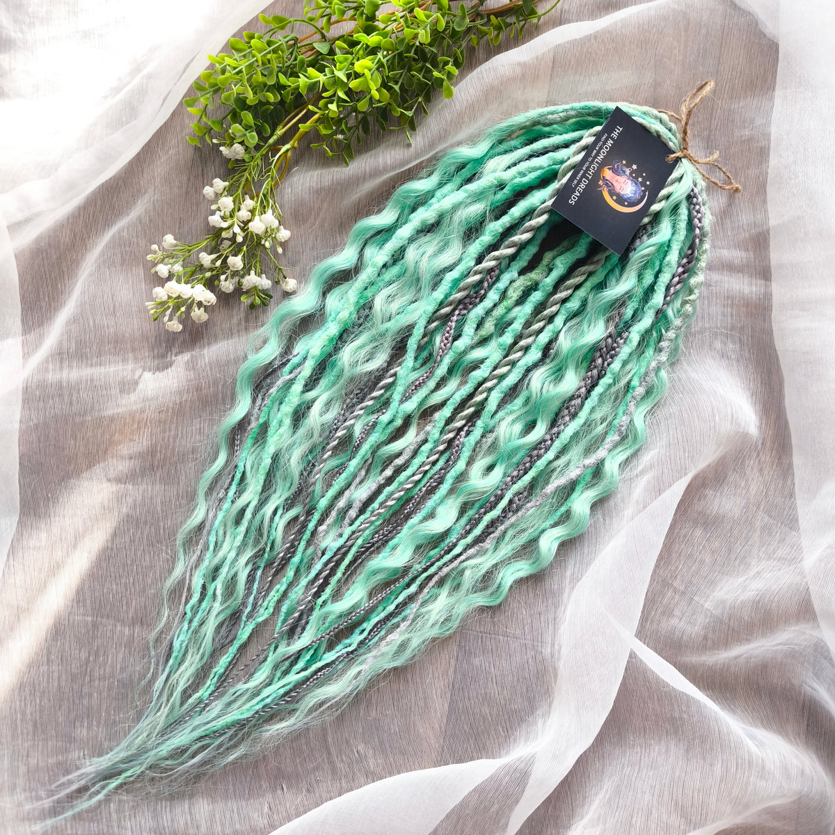Silver Mint: soft, lightweight, and reusable 20 double ended synthetic crochet dreadlocks, braids, and non-brushable curls in a soft blend of silver and aquamarine.
