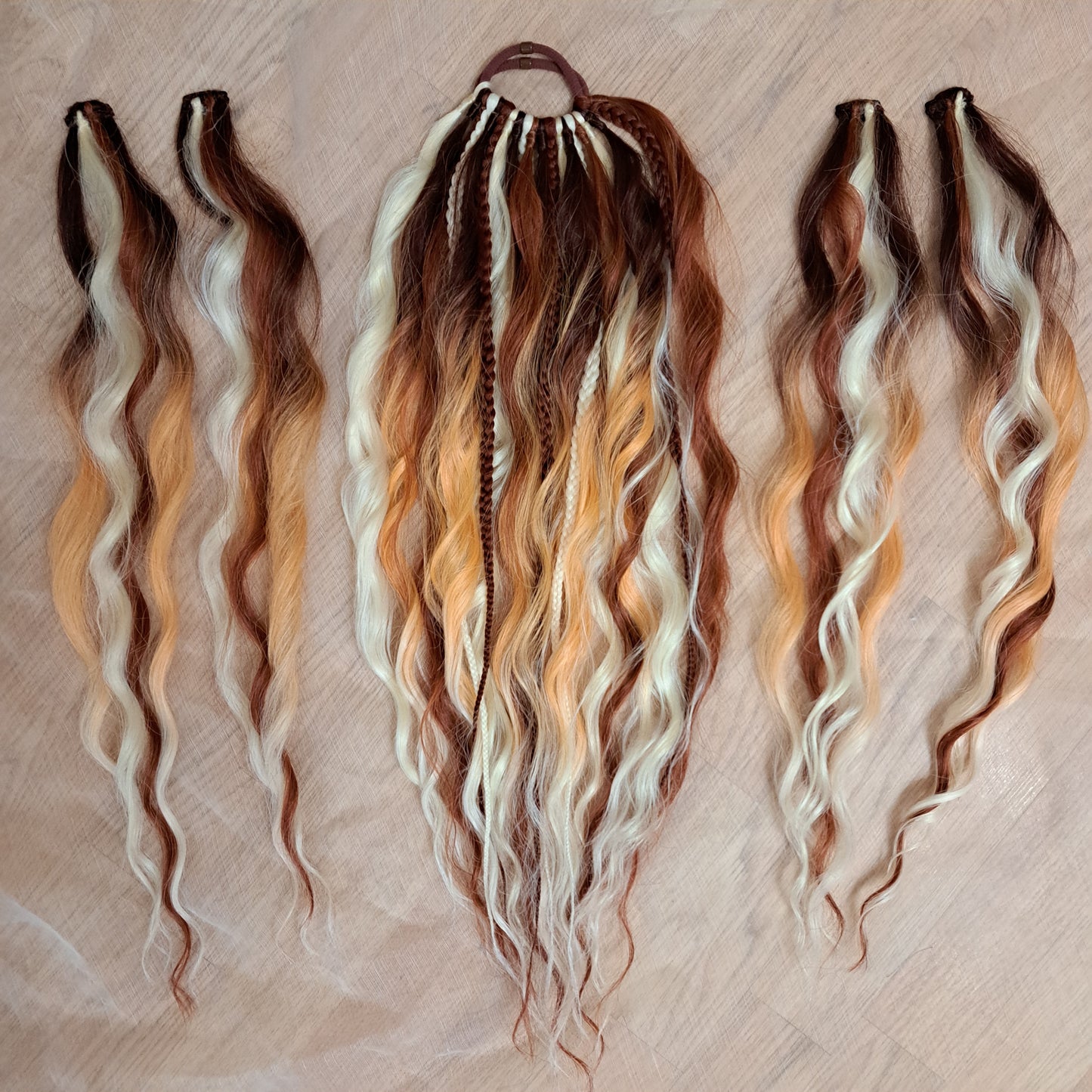 Braids, dreads, and curls on an elastic band — a simple way to transform a ponytail without installing a set. Easy to put on and remove whenever you like. A great option if you can’t install dreads or braids. Also, a perfect gift for kids 🎁

These scrunchies add instant length, volume, and texture — whether you prefer bold colors or natural shades.

Length: 22–24 inches.
Each hair tie includes 12–14 pieces, depending on the style.

Choose from the available designs shown, or contact us for a custom order.
