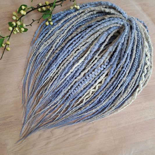 Soft, lightweight, and reusable 52 double ended synthetic bumpy dreadlocks &nbsp;and braids. This set combines soft ash-grey, muted ice blue, and pale cream shades. This cool-toned palette creates a calm, sophisticated look with a hint of coastal breeze and winter frost.

Length: 21 inches (≈53 cm)
Thickness of dreads and braids: ≈0.8-1 cm
Weight: 430 gr (≈15 oz)