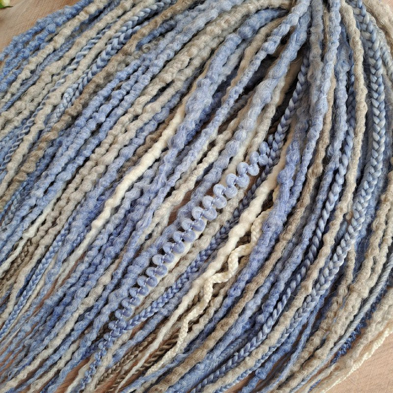 Soft, lightweight, and reusable 52 double ended synthetic bumpy dreadlocks &nbsp;and braids. This set combines soft ash-grey, muted ice blue, and pale cream shades. This cool-toned palette creates a calm, sophisticated look with a hint of coastal breeze and winter frost.

Length: 21 inches (≈53 cm)
Thickness of dreads and braids: ≈0.8-1 cm
Weight: 430 gr (≈15 oz)