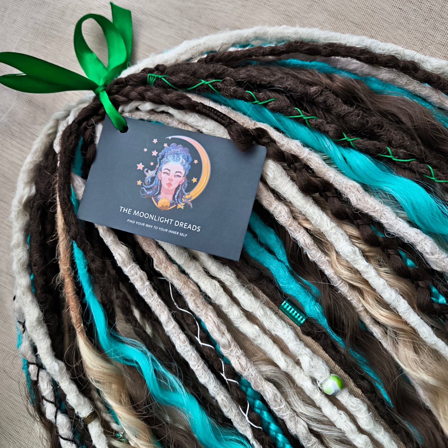 Brown, 2 shades of blonde, and turquoise green soft, lightweight, and reusable synthetic dreads, braids, and regular dreaded non-brushable curls (colors based on the Arctic Mocha brushable curls set)

The length is 22-24 inches (55-60 cm)
Dreaded part of curls: 4-5 inches
Thickness of braids ±0.8 cm