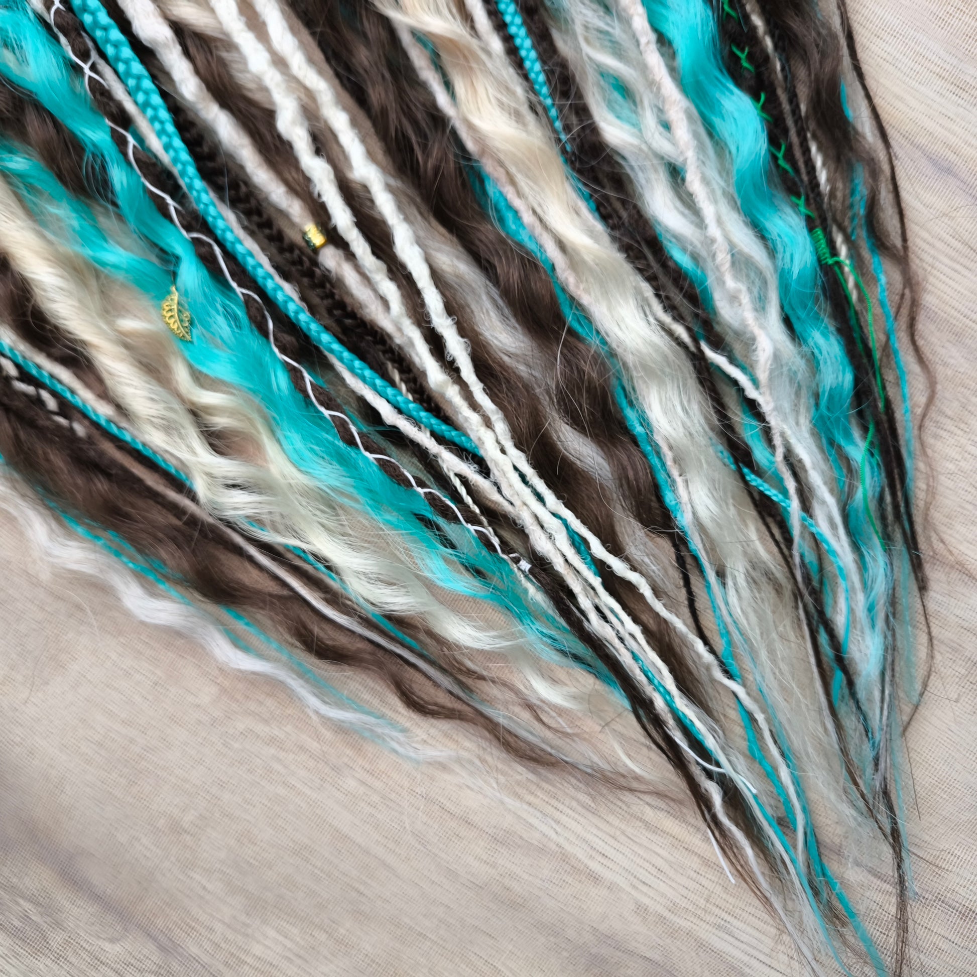 Brown, 2 shades of blonde, and turquoise green soft, lightweight, and reusable synthetic dreads, braids, and regular dreaded non-brushable curls (colors based on the Arctic Mocha brushable curls set)

The length is 22-24 inches (55-60 cm)
Dreaded part of curls: 4-5 inches
Thickness of braids ±0.8 cm