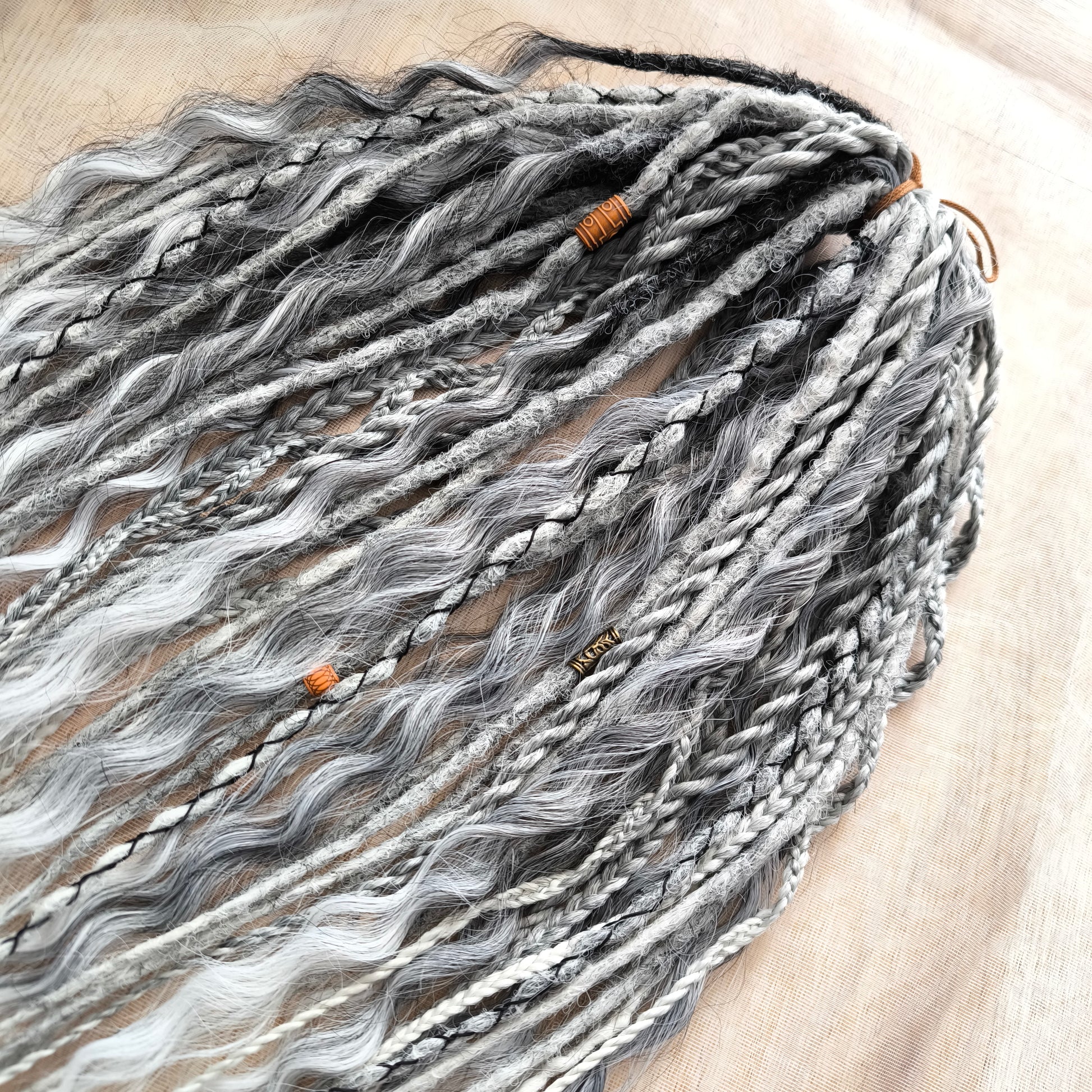 This set of synthetic dreadlocks combines elements of a Viking-inspired aesthetic.
Ombre from grey to platinum blonde double ended crochet dreads, braids, and Senegalese twists (curls optionally). Decoration is included. Reusable lightweight set made from high-quality synthetic hypoallergenic material kanekalon.

Standard length: ±22-24 inches (55-60 cm)
Thickness of dreads and braids: ±0.8 cm
Dreaded part of curls: ±3-4 inches (8-10 cm)