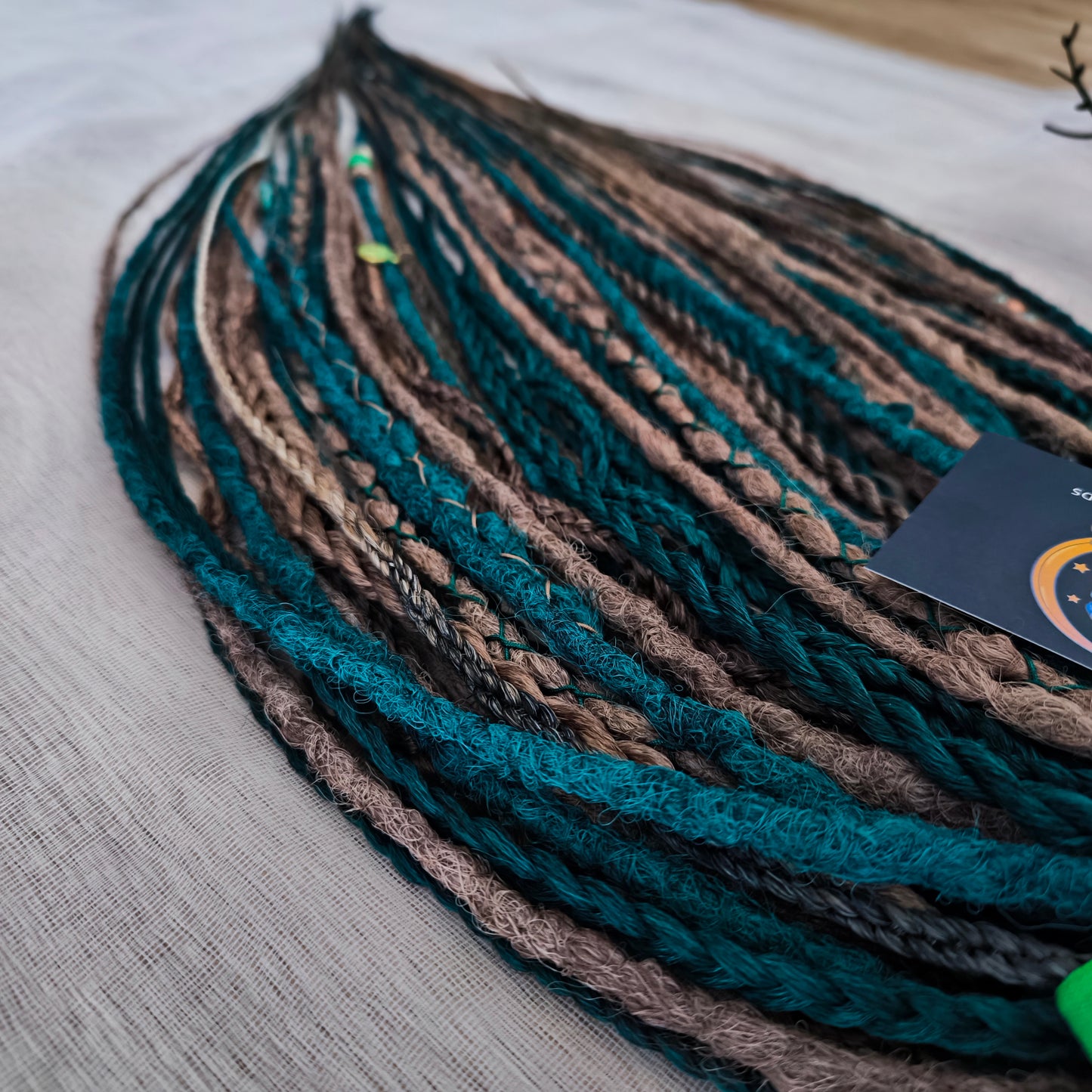 synthetic set of double ended crochet dreadlocks, braids, Senegalese twists in forest green and a few tints of brown colors.