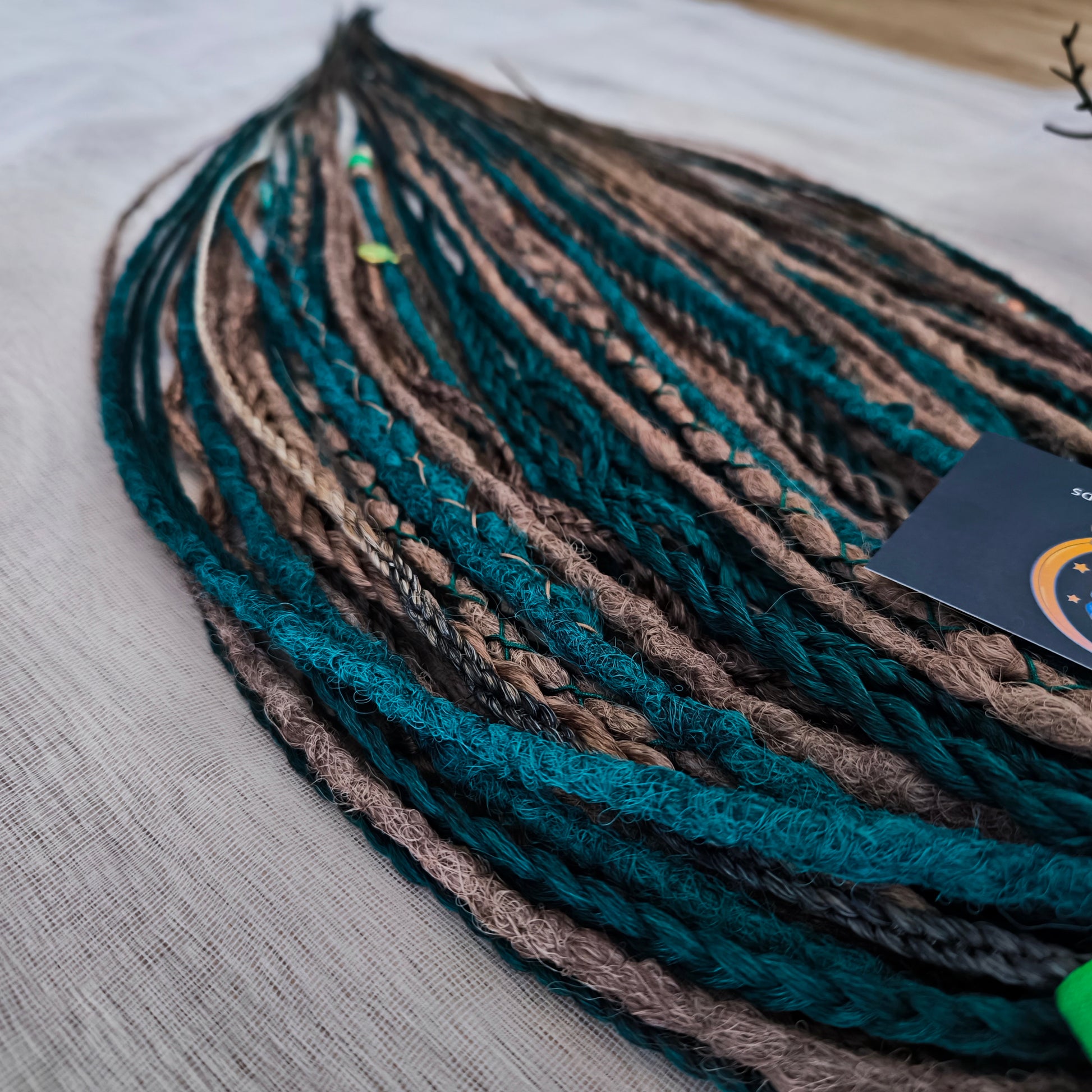 synthetic set of double ended crochet dreadlocks, braids, Senegalese twists in forest green and a few tints of brown colors.