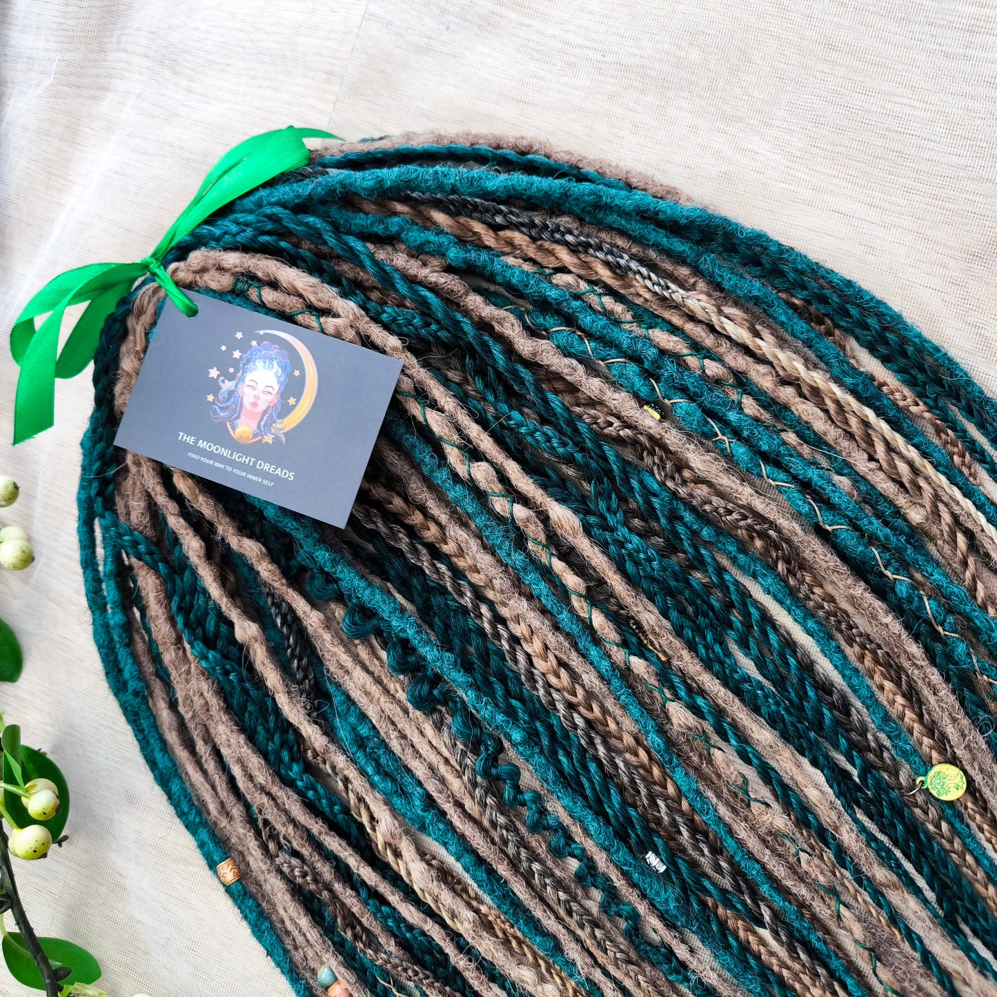 synthetic set of double ended crochet dreadlocks, braids, Senegalese twists in forest green and a few tints of brown colors.