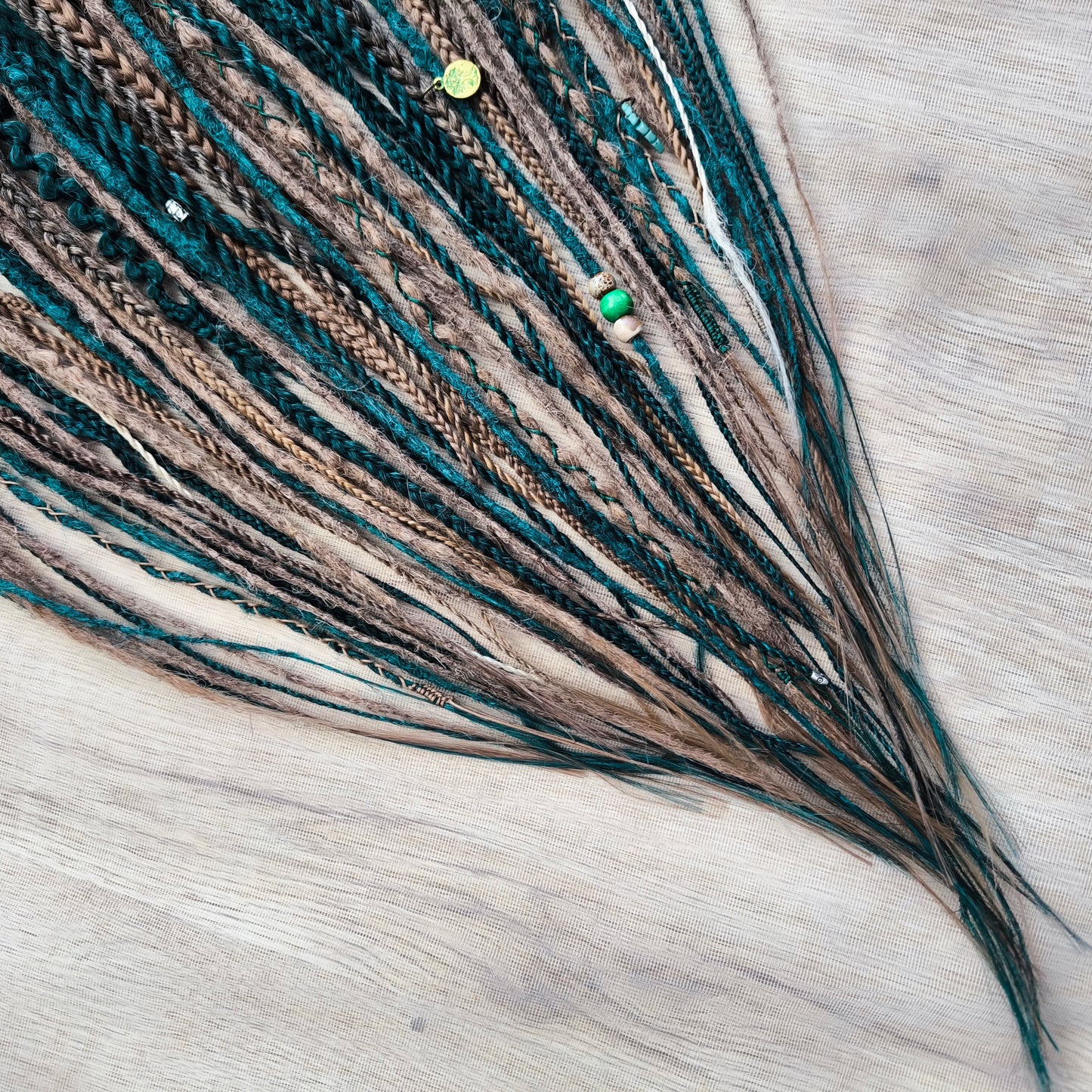 synthetic set of double ended crochet dreadlocks, braids, Senegalese twists in forest green and a few tints of brown colors.