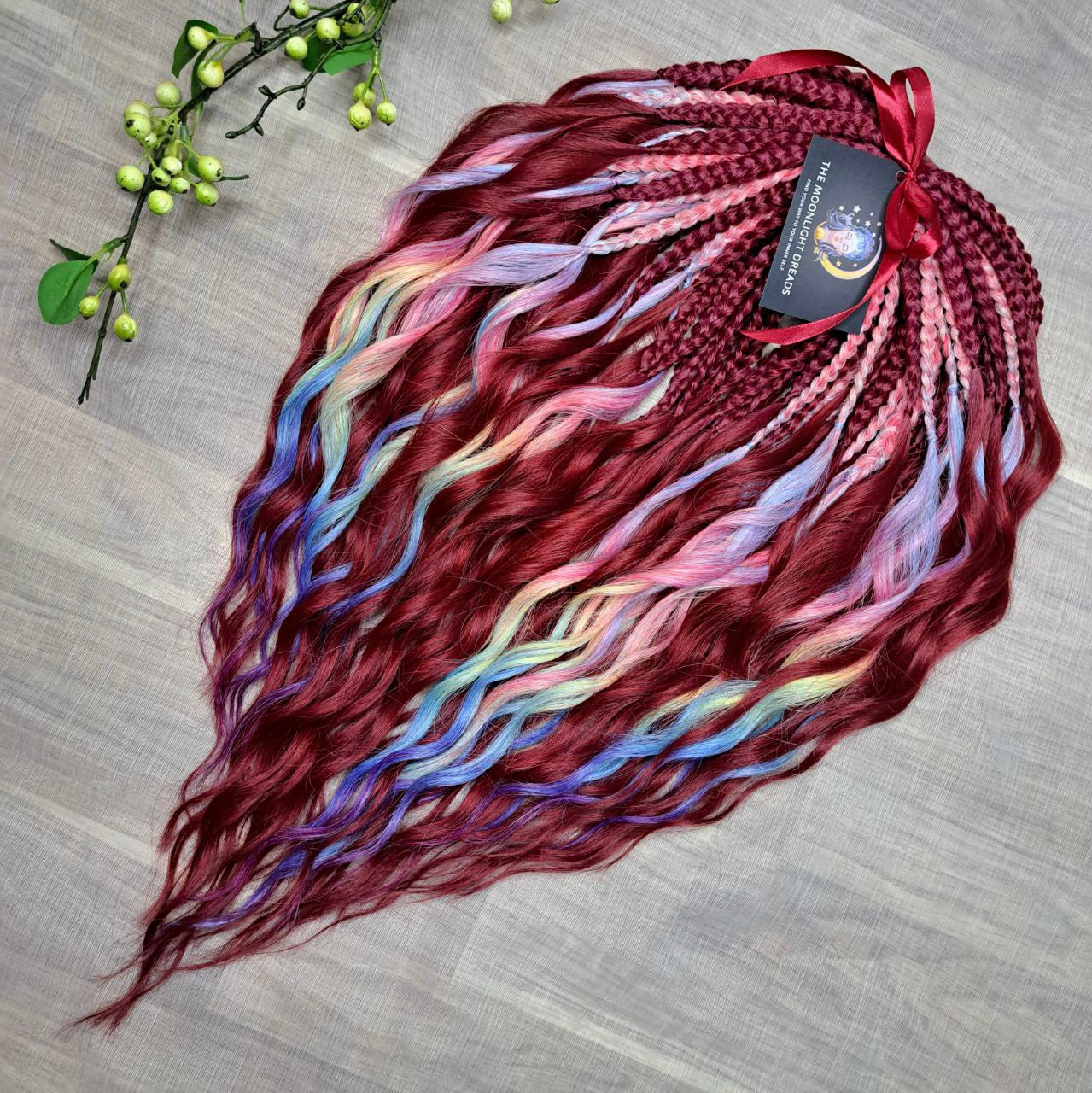 Deep berry red base with pastel highlights in blue, lilac, pink, and soft yellow - bold contrast with a smooth flow of color. Soft, lightweight, and reusable synthetic brushable double ended wavy dreadlocks. Bring the burst 💥
