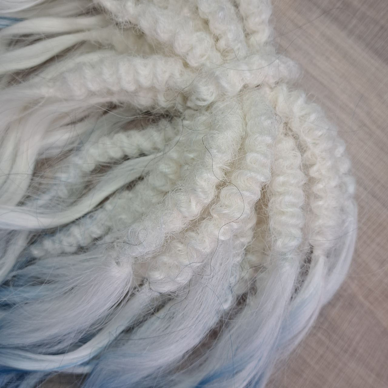 Ombre from clean icy blonde roots into smoky steel blue, deepening into rich navy blue at the ends - soft, lightweight, brushable, and reusable synthetic double-ended brushable curls (regular dreaded, braided middle or push-up).