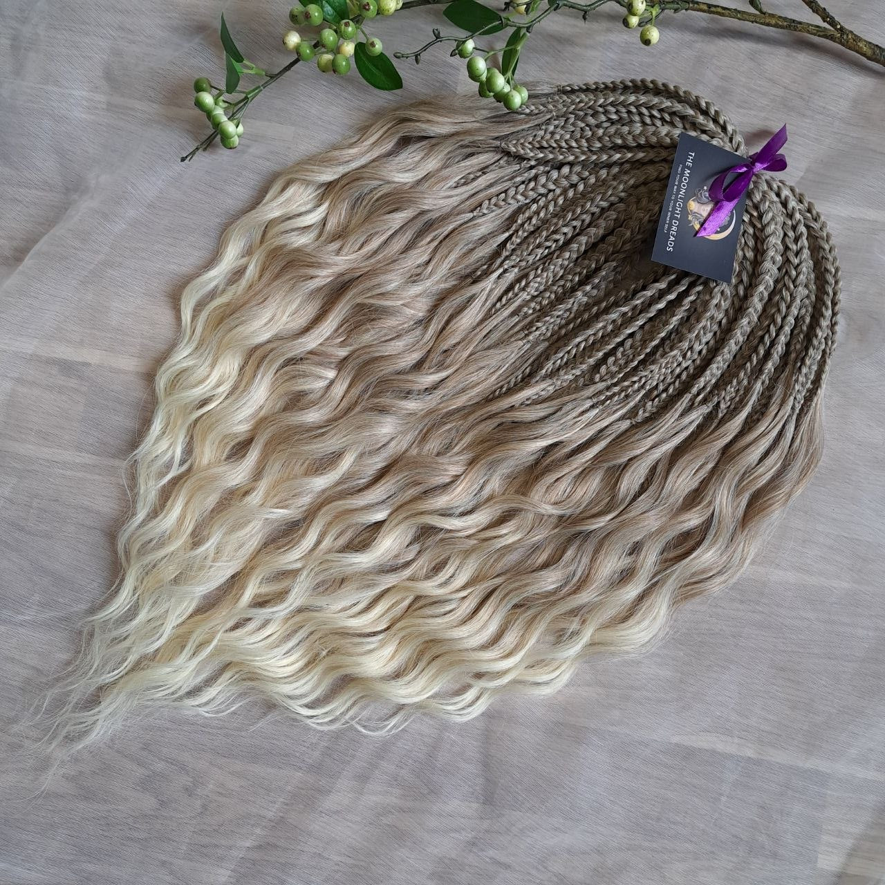 Ready to ship: soft, lightweight, and reusable 50 double ended synthetic brushable curls with braided middle. Soft natural gradient in warm neutral tones.

Roots in muted dark blonde with a subtle ash-beige (taupe) undertone, gradually blending into a warm beige-wheat blonde, and finishing in a light creamy, almost platinum vanilla blonde at the ends.
