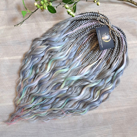 Moon Pearl - soft, lightweight, and reusable synthetic brushable double ended wavy dreadlocks (regular dreaded, braided middle, or push-up).

A blend of pearl grey, icy blue, soft mint, lavender, and blush pink - subtle, airy, and full of depth. The pastel shades appear gently throughout the set, creating a shimmering effect without overpowering the base color.