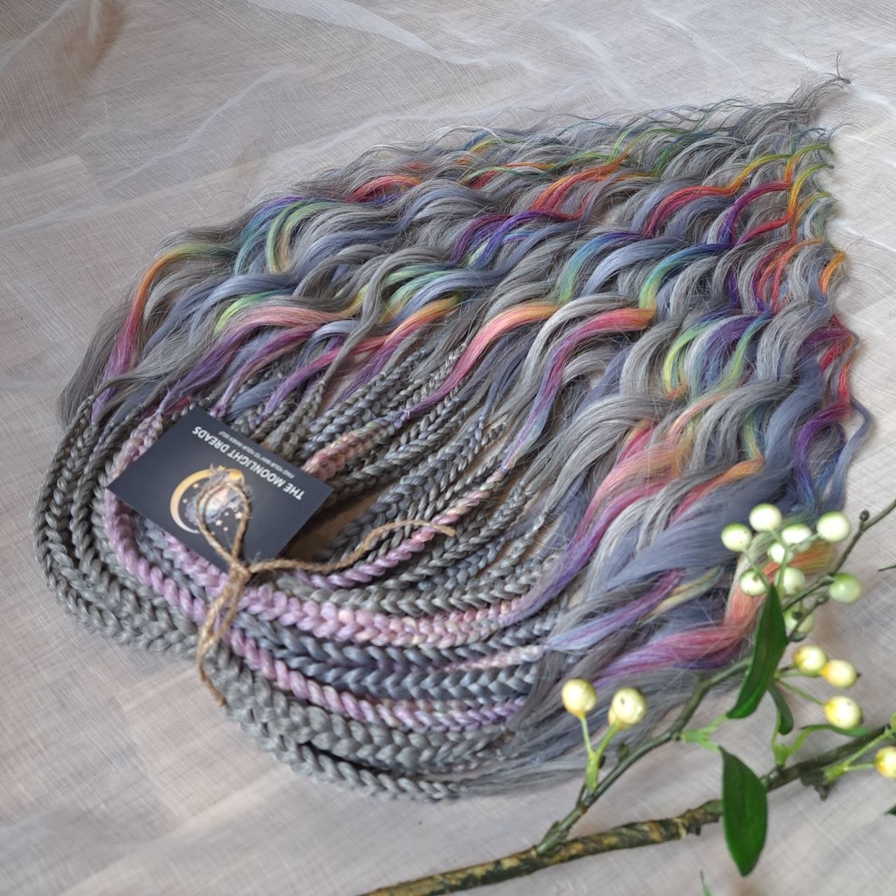 Silver Rainbow - soft, lightweight, and reusable synthetic brushable double ended wavy dreadlocks (regular dreaded, braided middle, or push-up).

A silver-grey base with vibrant rainbow accents. Bright pops of color stand out against the cool smoky background, creating a playful yet balanced look.