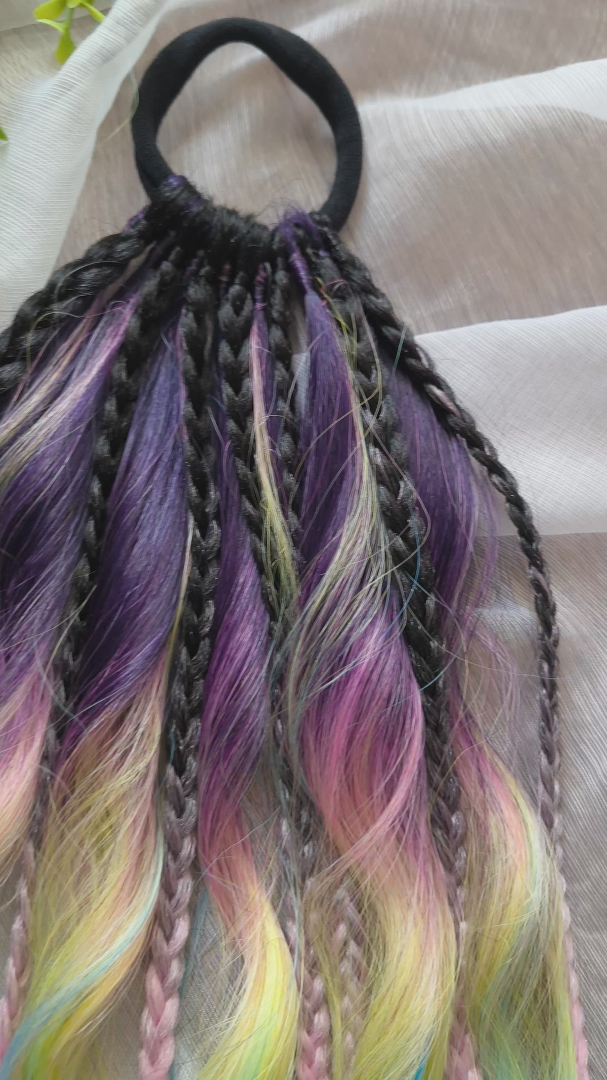 Gradient from deep purple to yellow, pink, and blue braids and curls on an elastic band — a simple way to transform a ponytail without installing a set. Easy to put on and remove whenever you like. A great option if you can’t install dreads or braids. Also, a perfect gift for kids