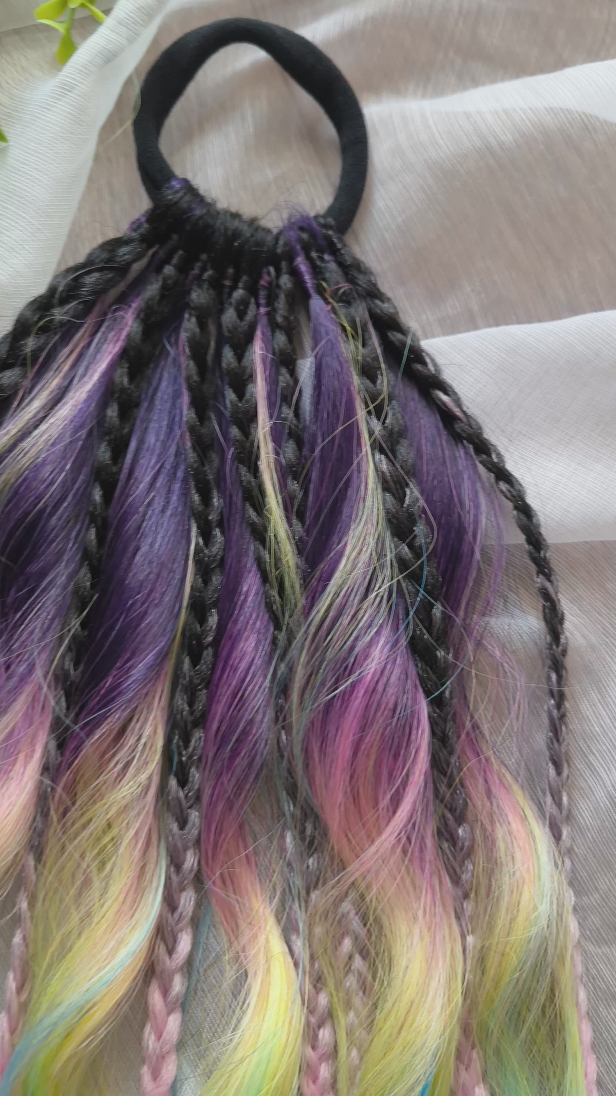 Gradient from deep purple to yellow, pink, and blue braids and curls on an elastic band — a simple way to transform a ponytail without installing a set. Easy to put on and remove whenever you like. A great option if you can’t install dreads or braids. Also, a perfect gift for kids