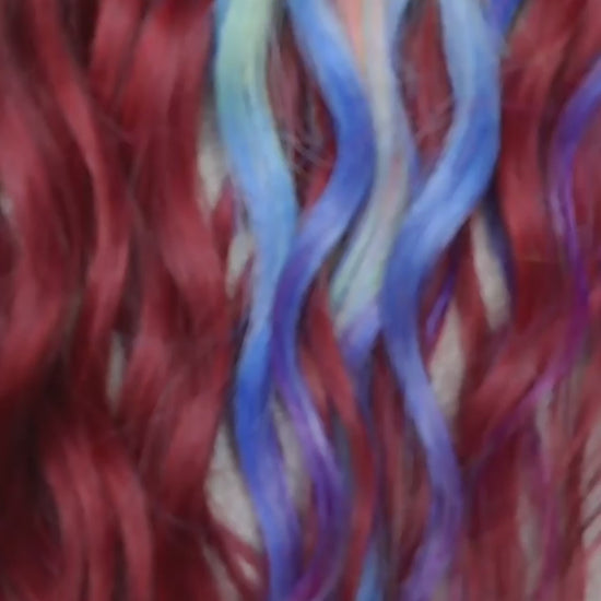Deep berry red base with pastel highlights in blue, lilac, pink, and soft yellow - bold contrast with a smooth flow of color. Soft, lightweight, and reusable synthetic brushable double ended wavy dreadlocks. Bring the burst 💥
