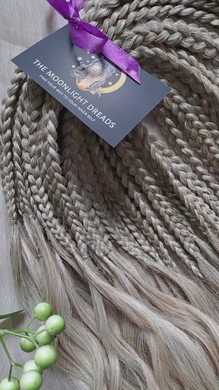 Ready to ship: soft, lightweight, and reusable 50 double ended synthetic brushable curls with braided middle. Soft natural gradient in warm neutral tones.

Roots in muted dark blonde with a subtle ash-beige (taupe) undertone, gradually blending into a warm beige-wheat blonde, and finishing in a light creamy, almost platinum vanilla blonde at the ends.